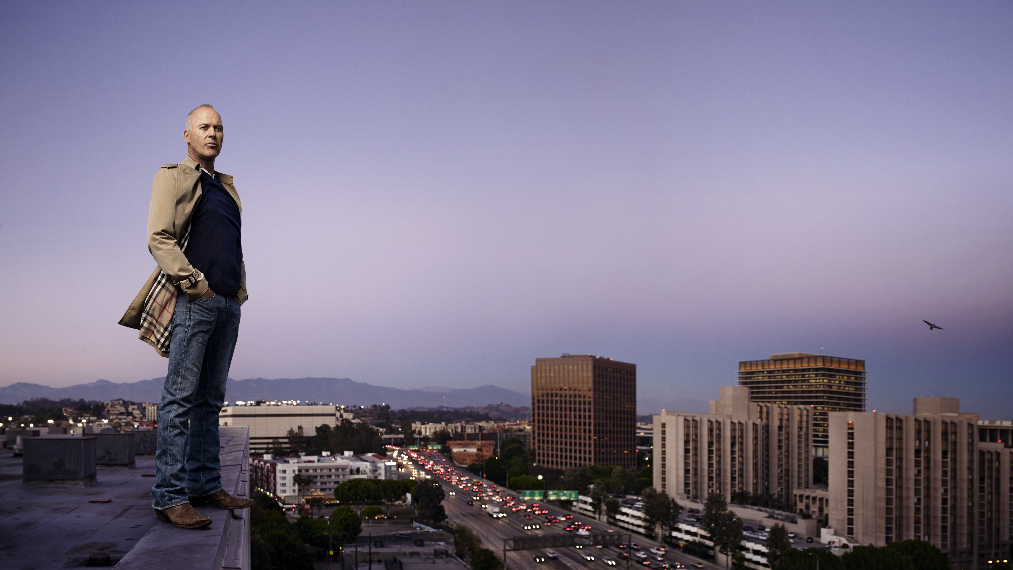 Michael Keaton on a rooftop overlooking a city HD Wallpaper