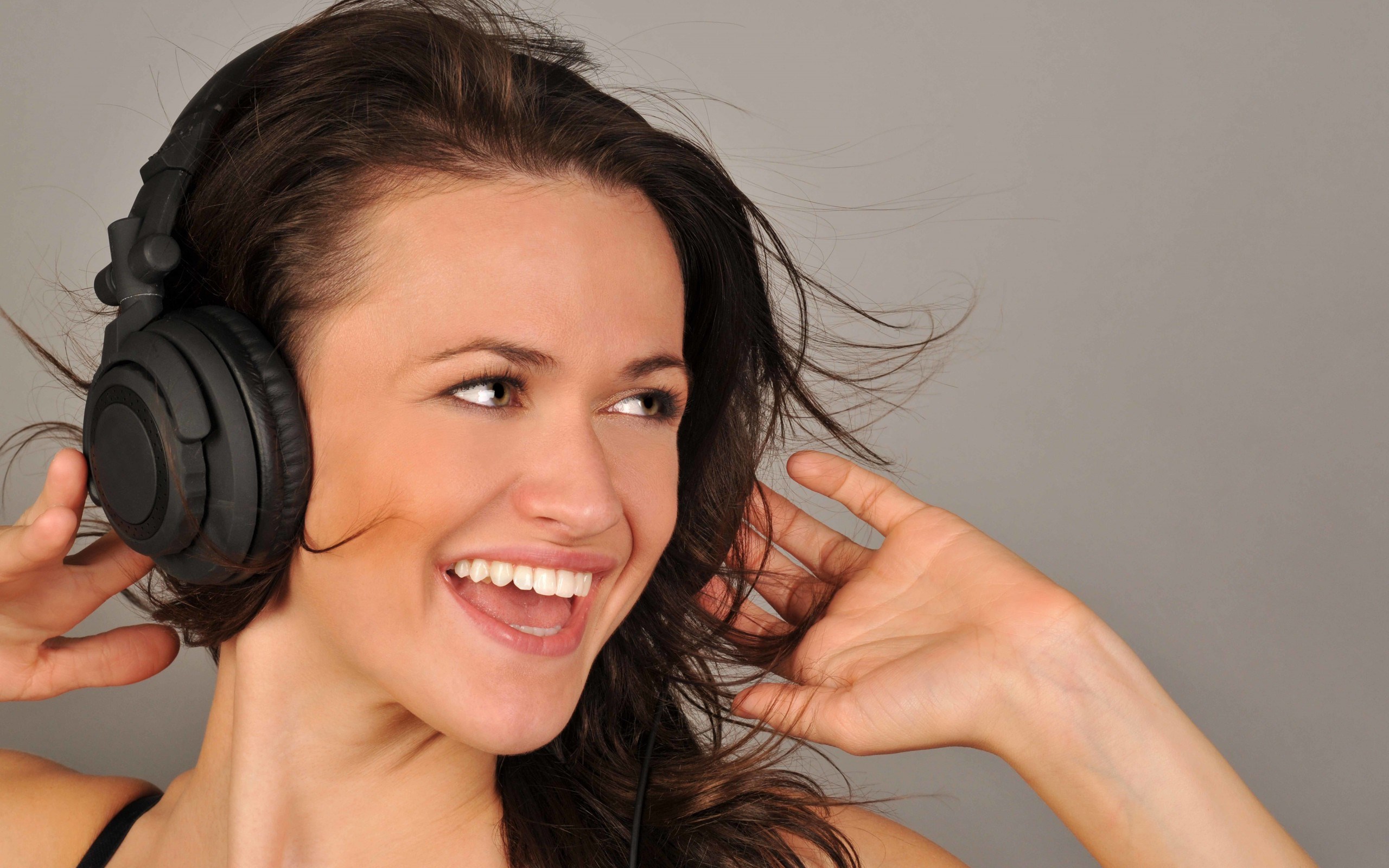Woman wearing headphones and smiling HD Wallpaper