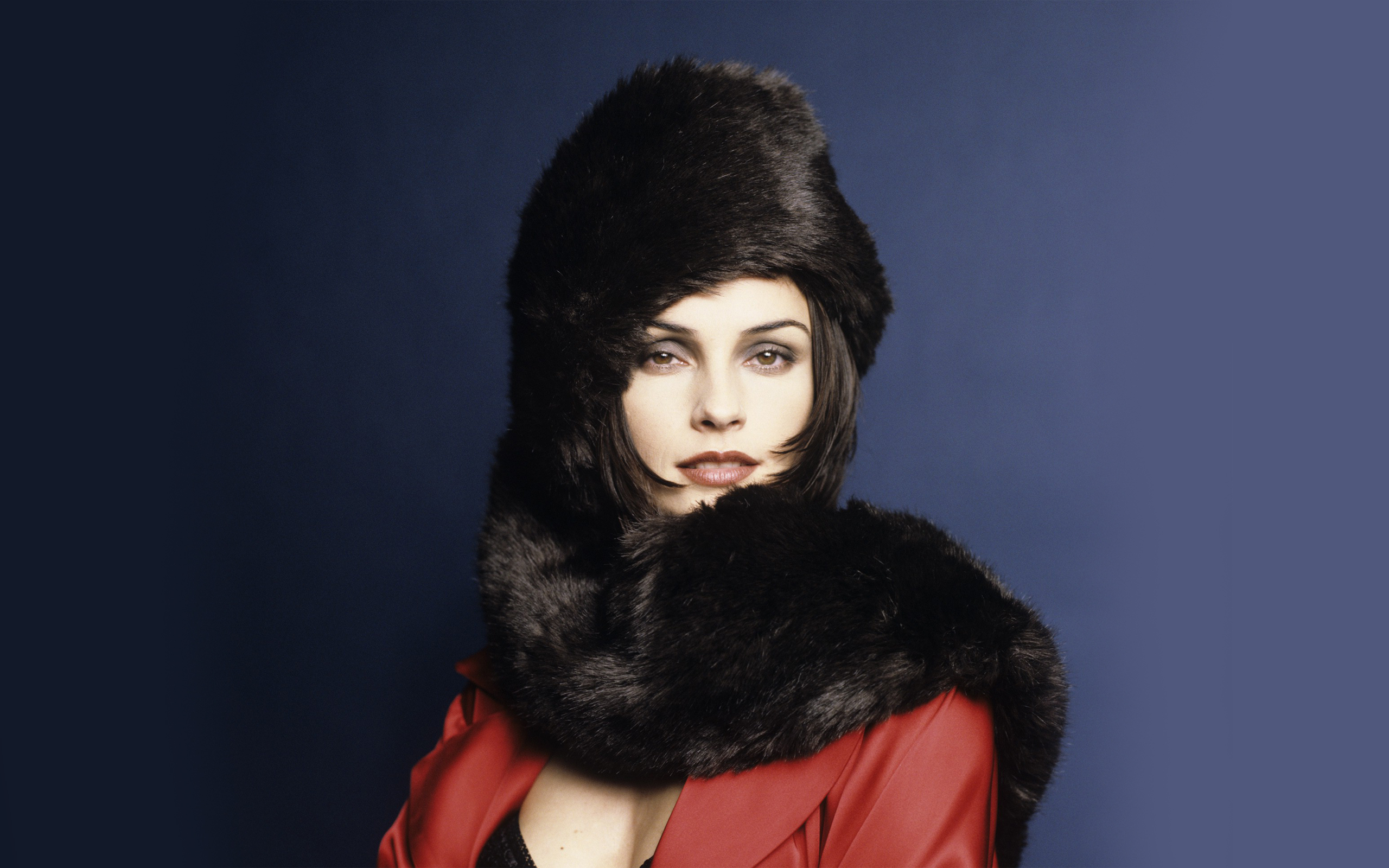 Famke Janssen wearing a black fur hat and red coat HD Wallpaper