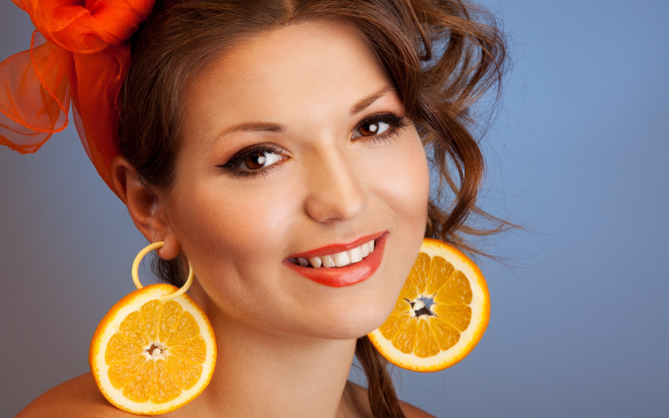 Woman with orange slice earrings and orange headscarf HD Wallpaper