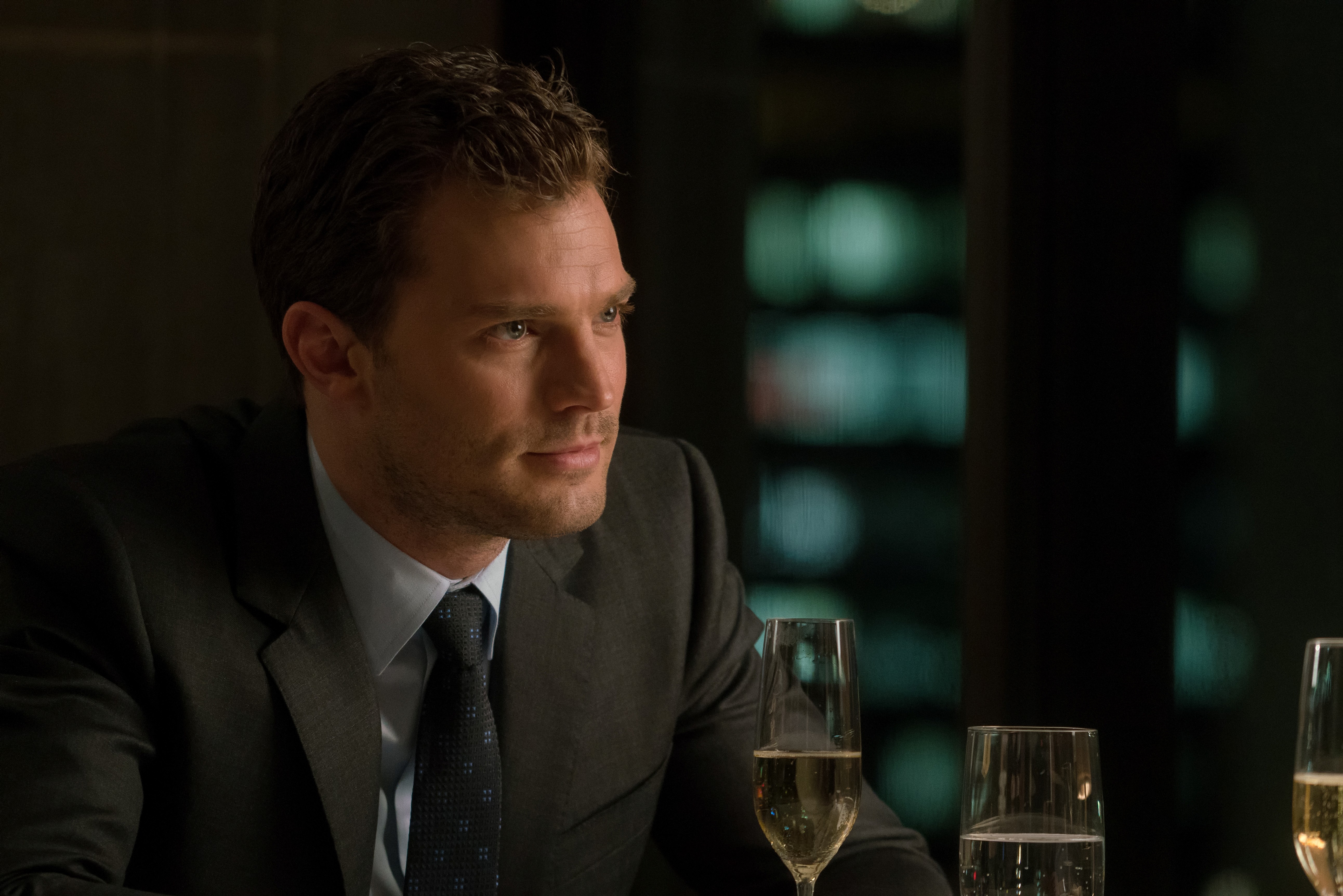 Jamie Dornan in a suit with champagne HD Wallpaper