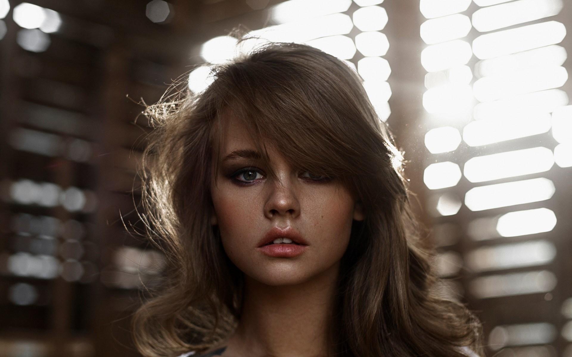 Woman with windblown hair in front of lights HD Wallpaper