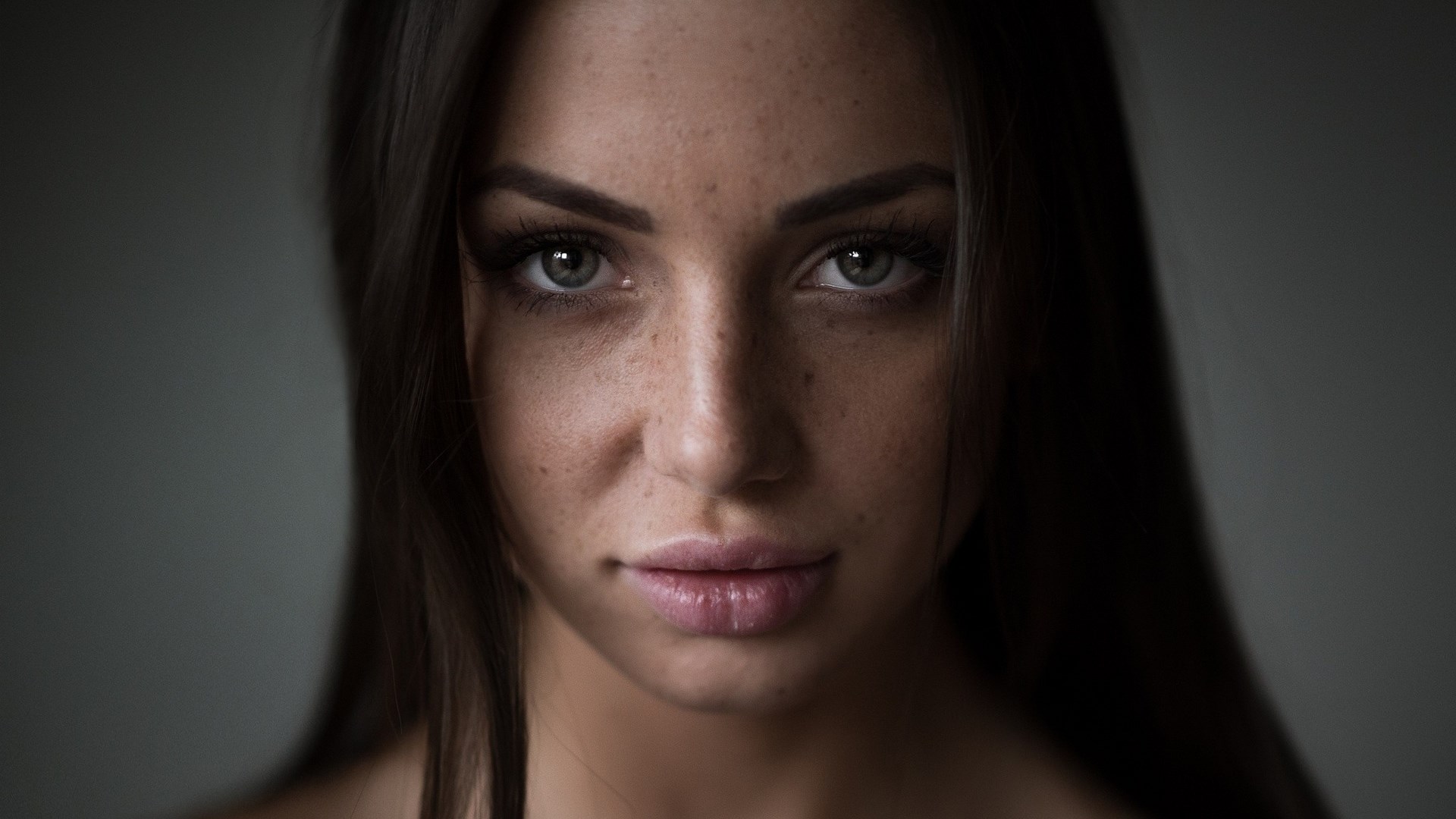 Woman with freckles looking at the camera HD Wallpaper