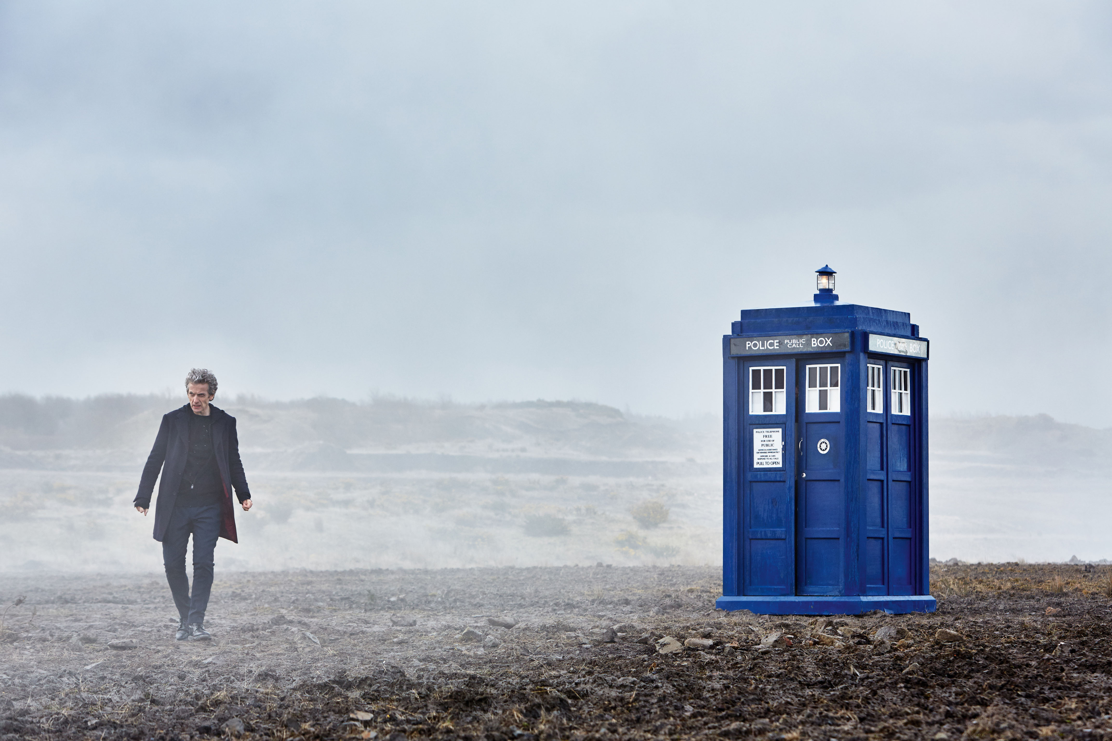 Peter Capaldi and the TARDIS on a misty landscape HD Wallpaper