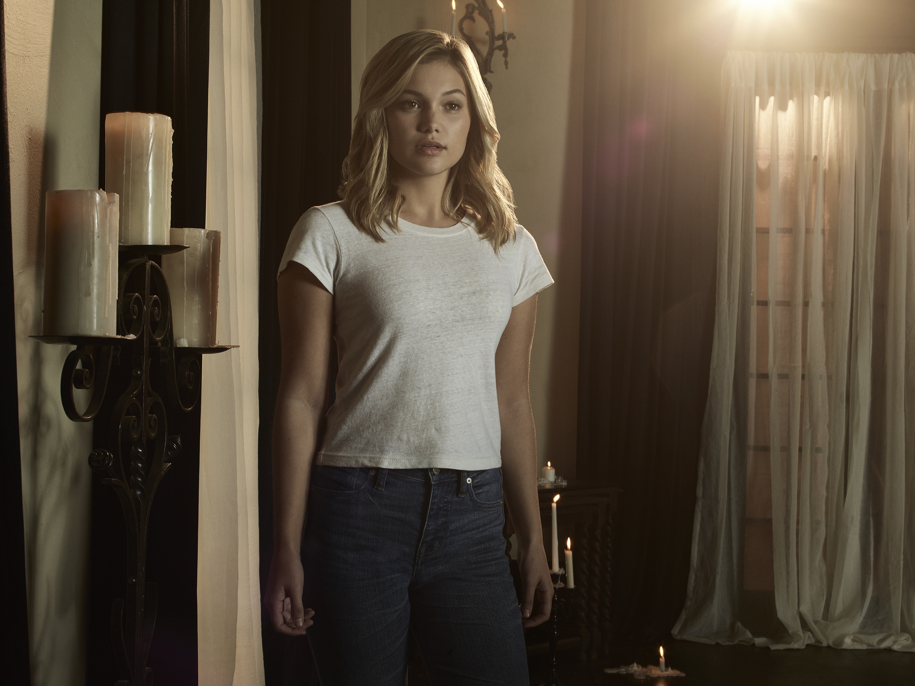 Olivia Holt in a dimly lit room HD Wallpaper