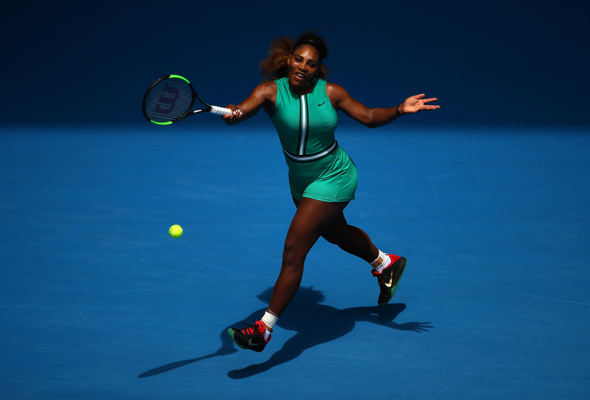 Serena Williams playing tennis on a blue court HD Wallpaper