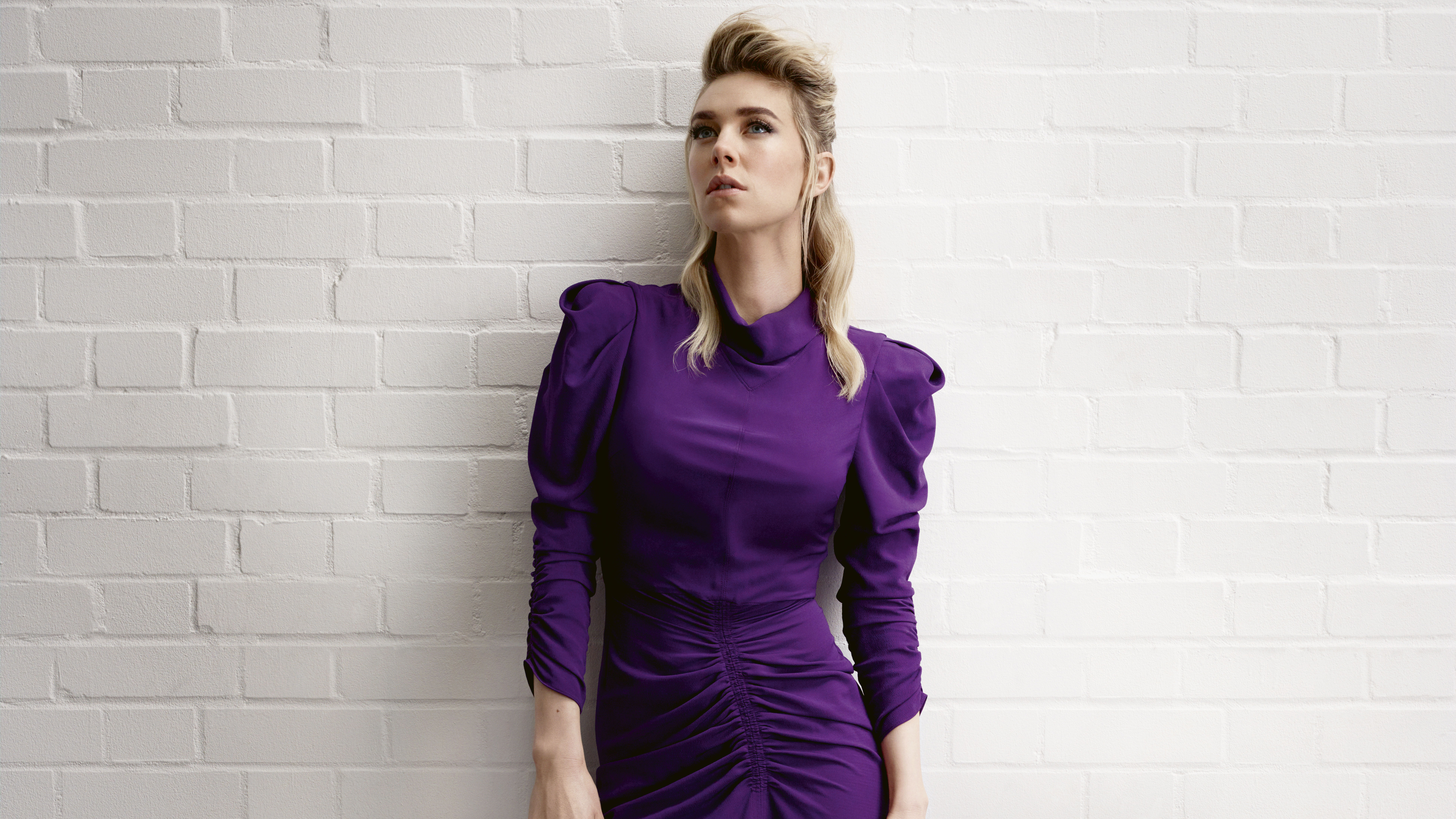 Vanessa Kirby in purple dress against white brick wall HD Wallpaper
