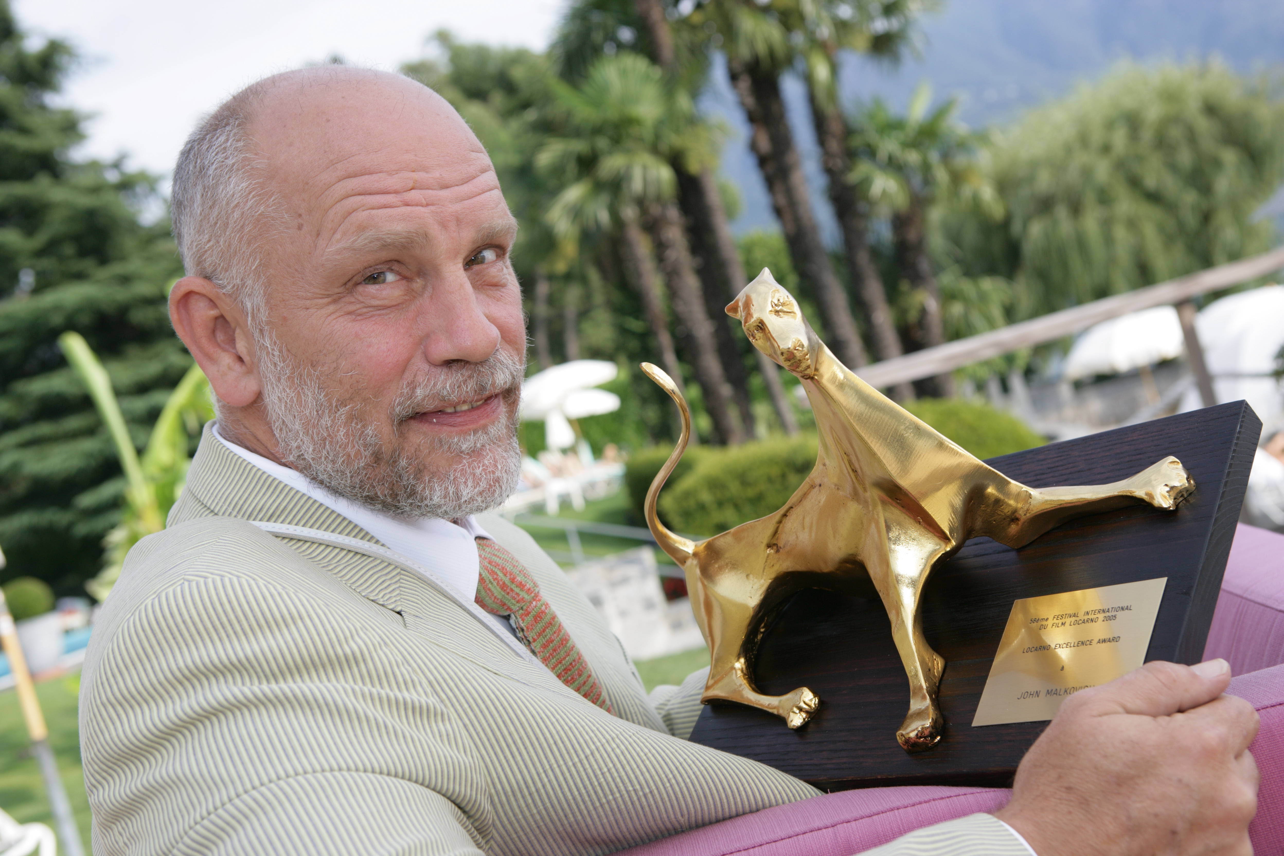John Malkovich holding a Golden Leopard award HD Wallpaper