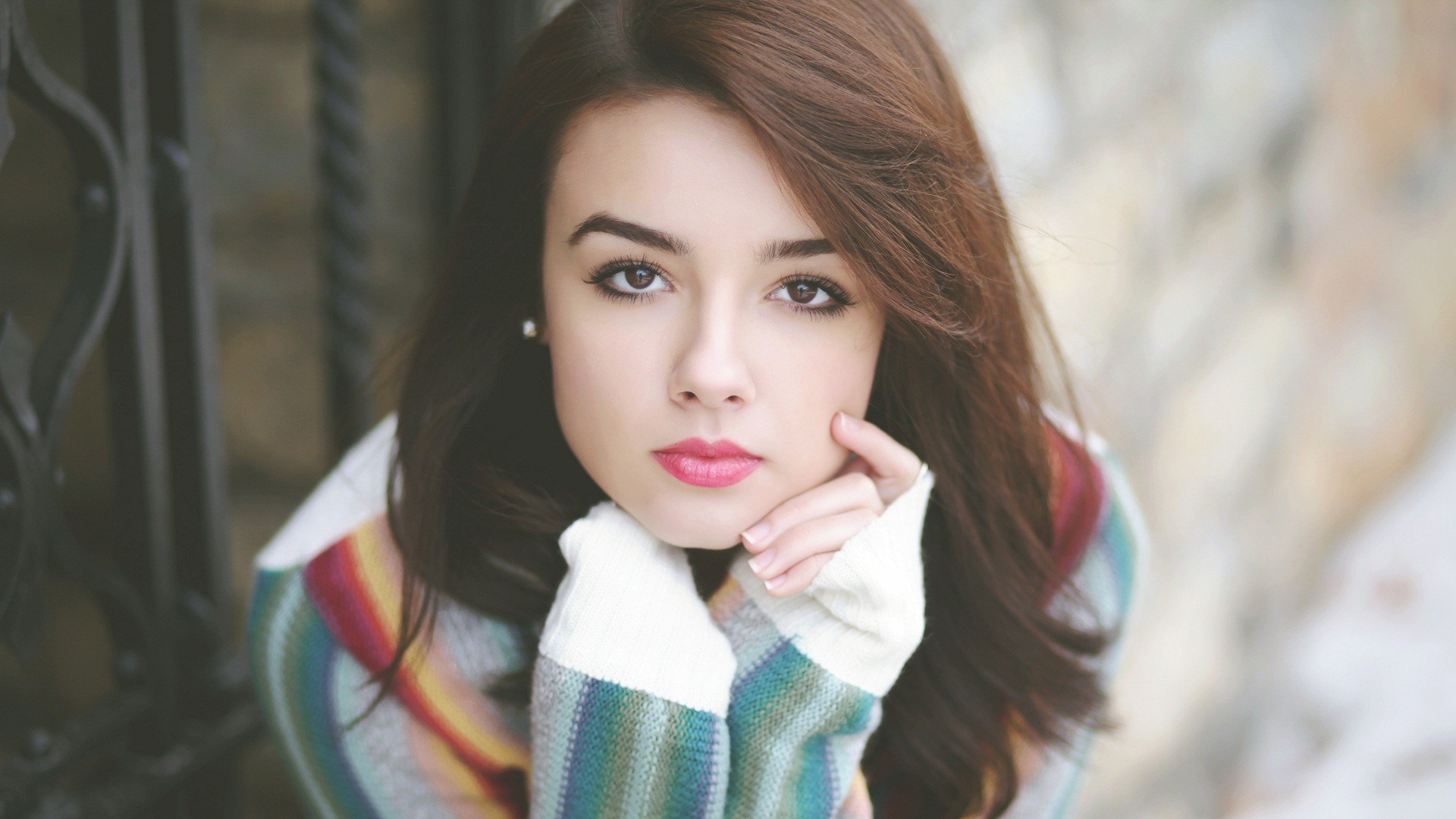 Young woman with brown hair wearing a colorful sweater HD Wallpaper