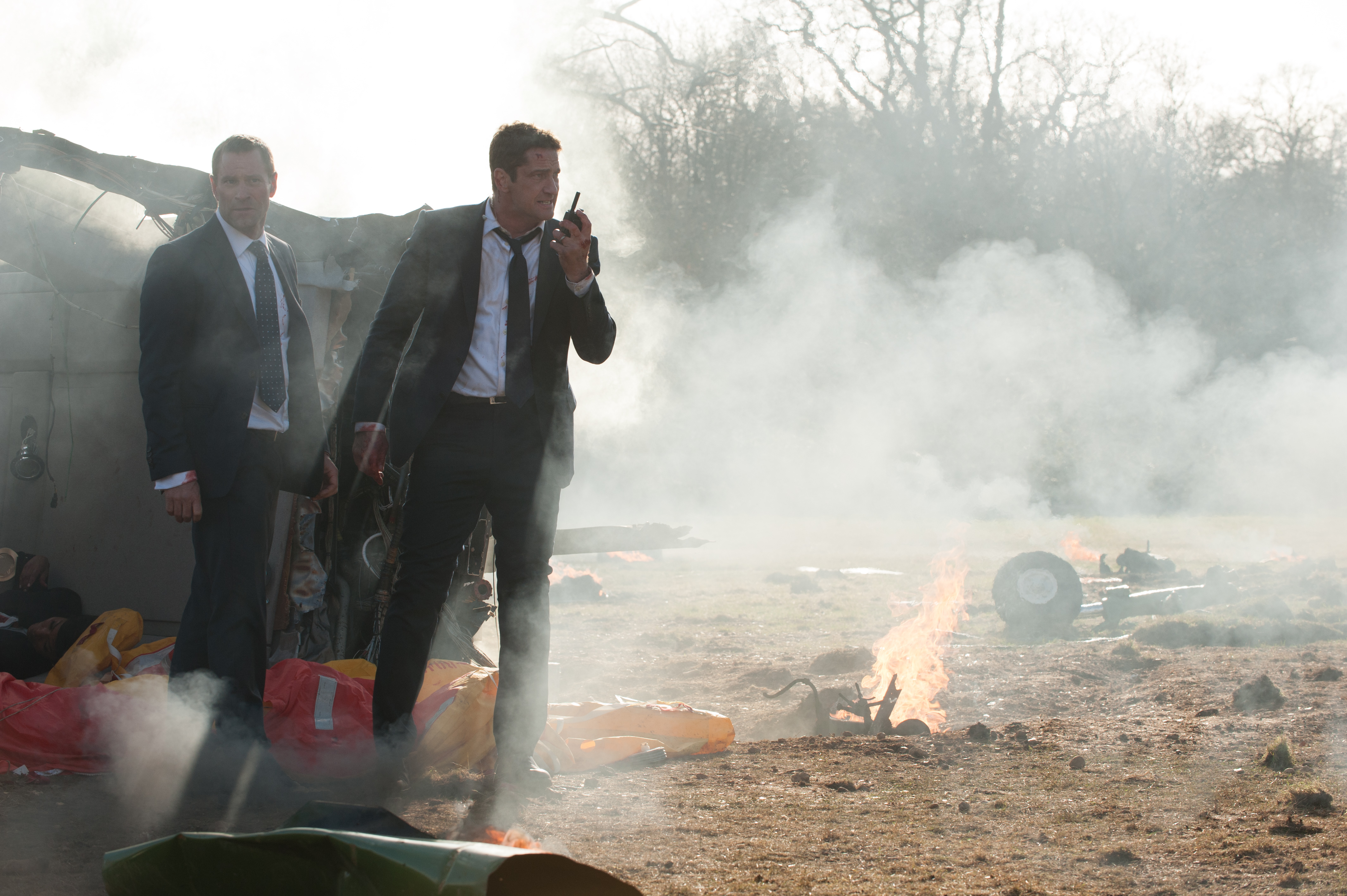 Aaron Eckhart in a suit with a crashed vehicle HD Wallpaper