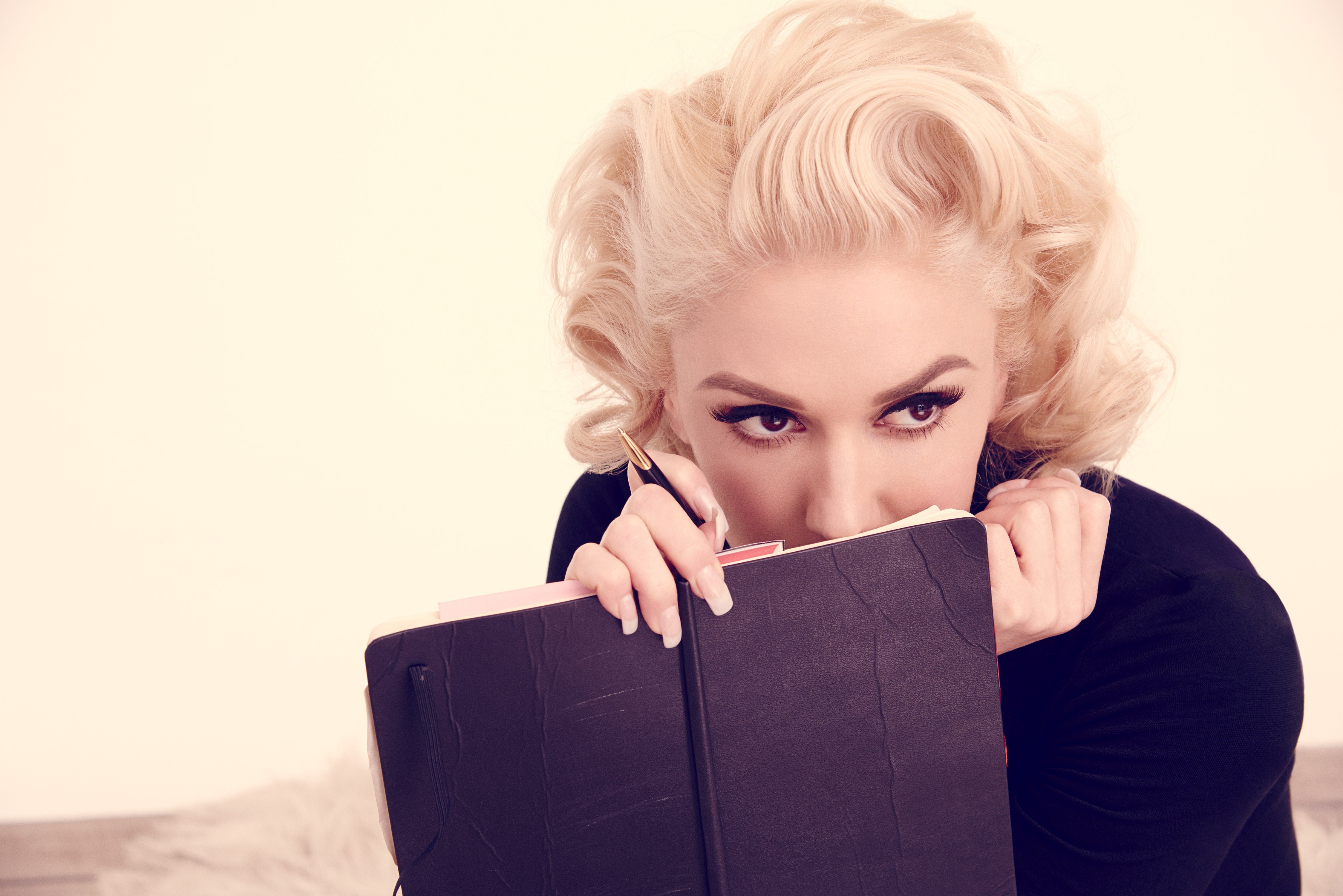 Gwen Stefani holding a notebook and pen HD Wallpaper