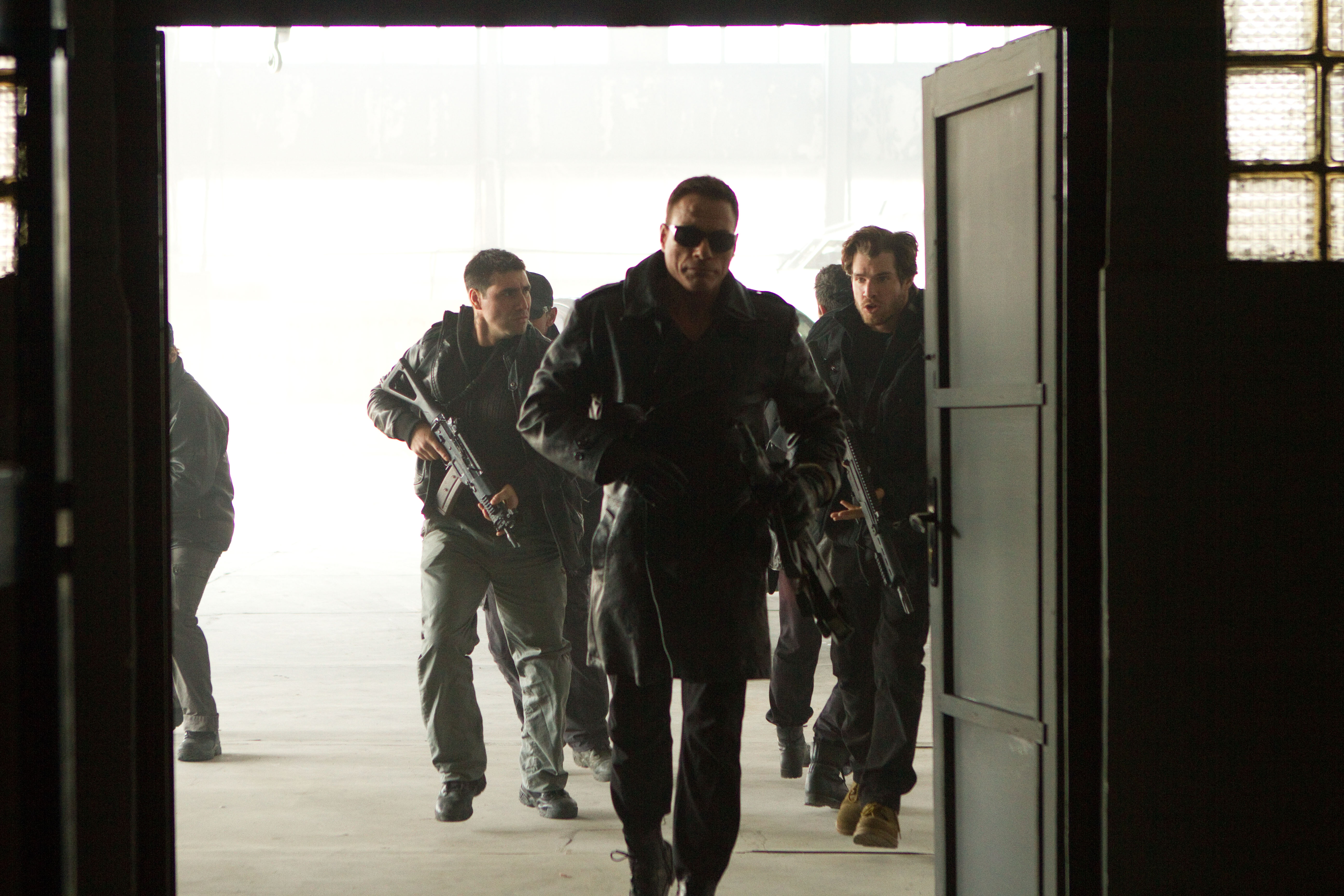 Jean-Claude Van Damme and armed men entering a building HD Wallpaper