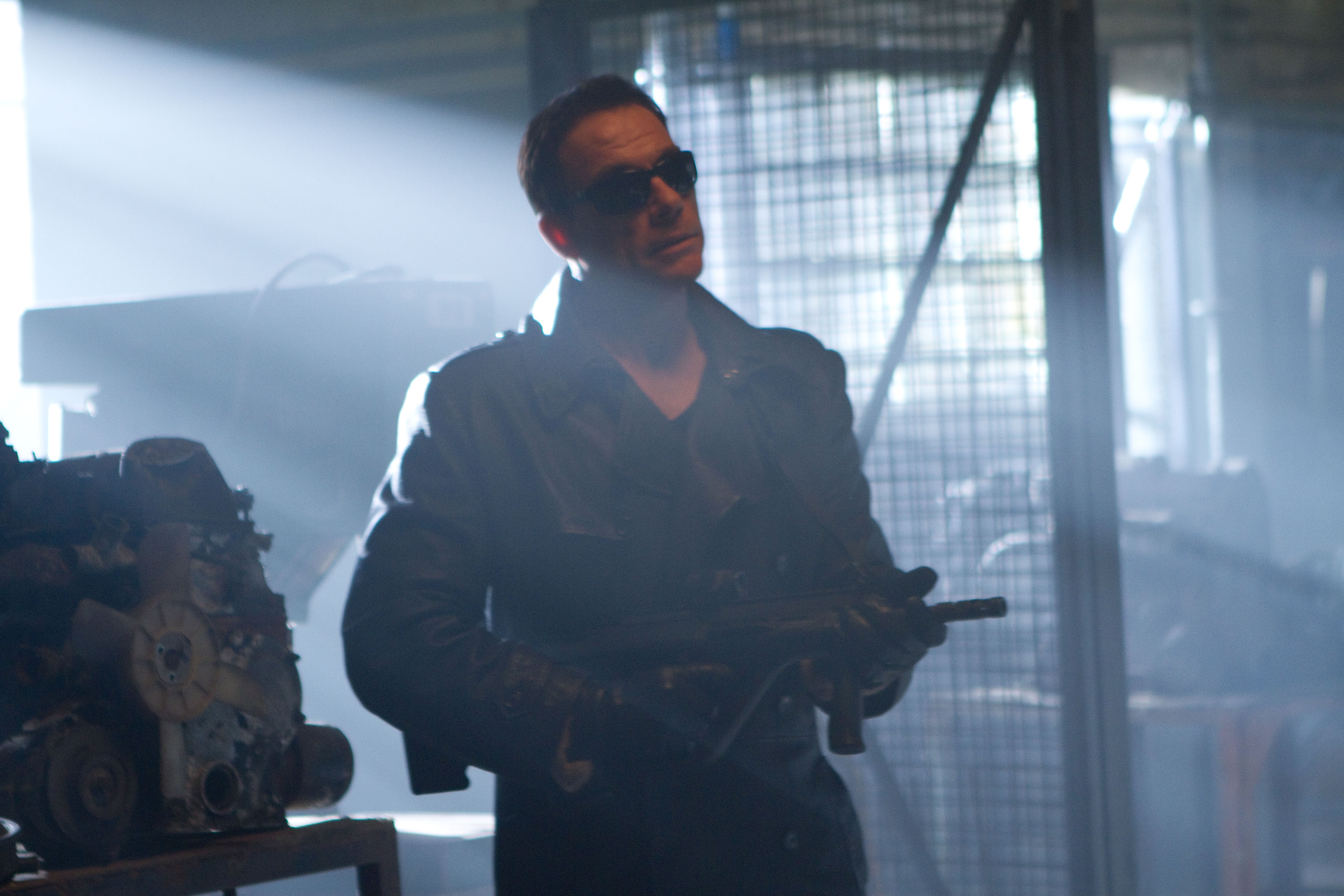Jean-Claude Van Damme holding a submachine gun HD Wallpaper