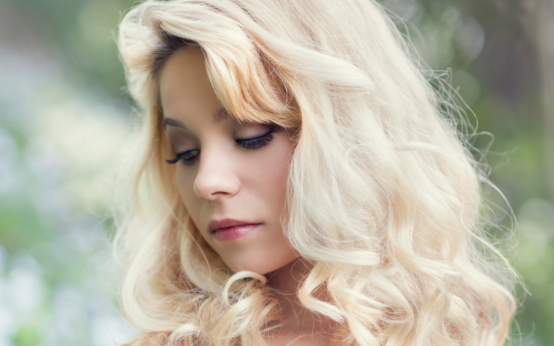 Woman with blonde curly hair looking down HD Wallpaper