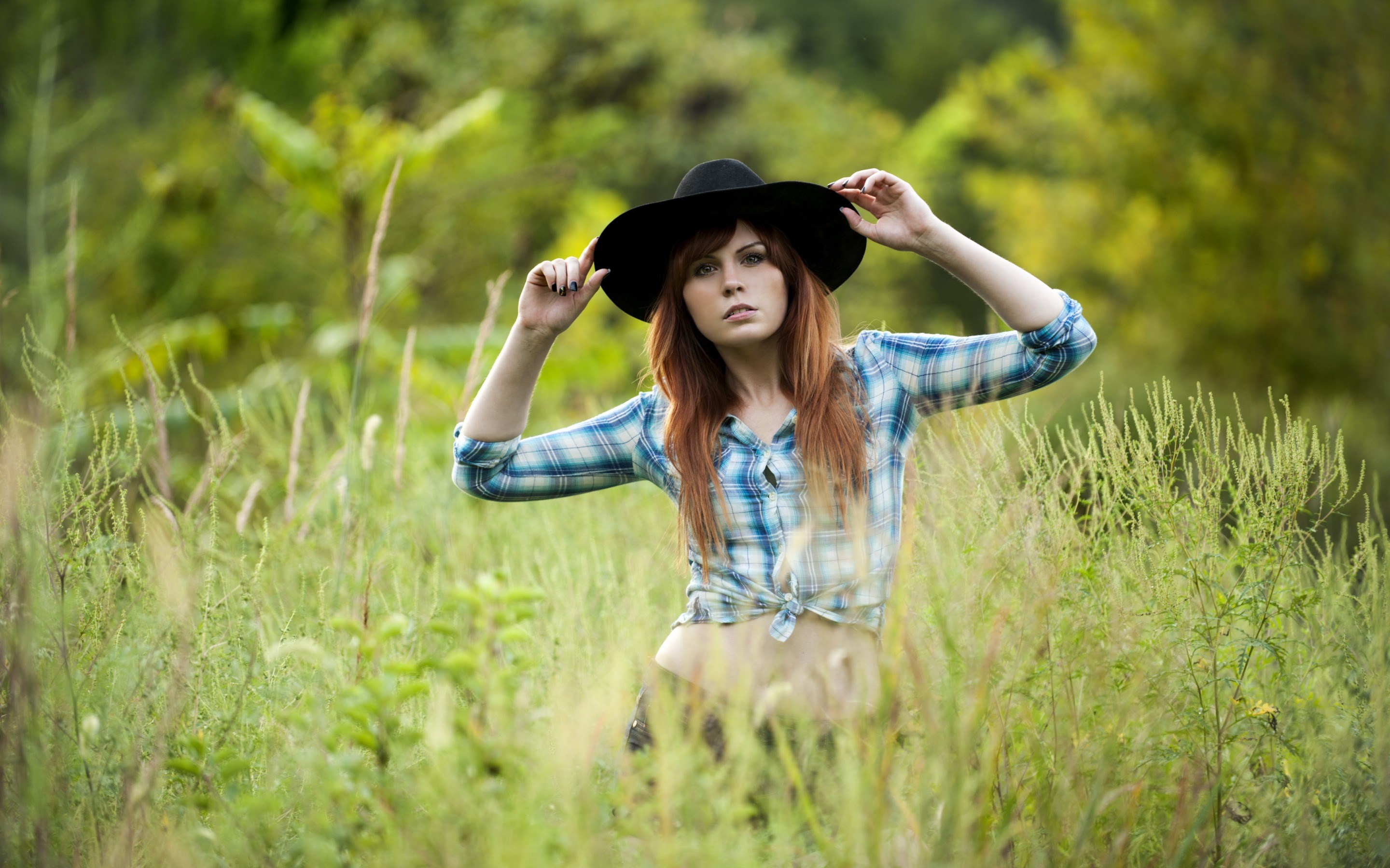 Woman in a hat and plaid shirt in a field HD Wallpaper