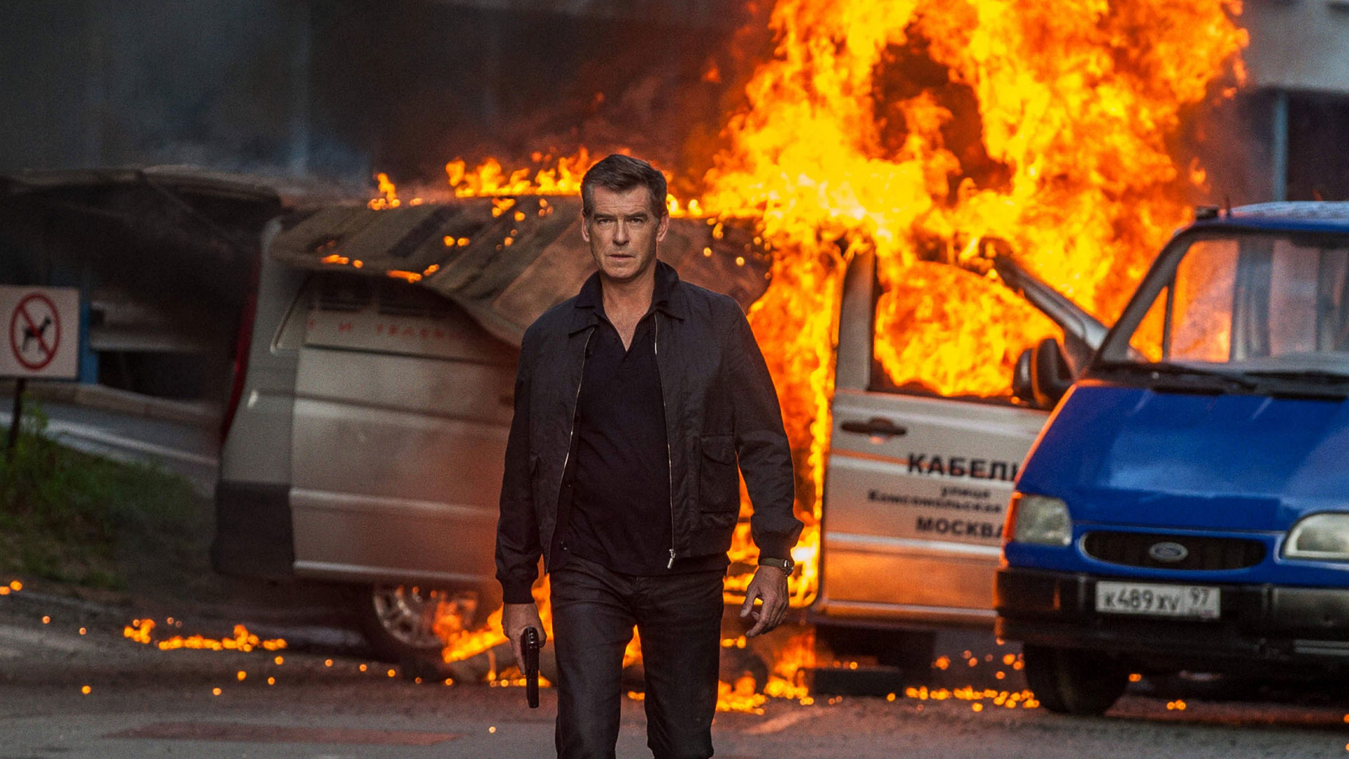 Pierce Brosnan in action scene with burning cars HD Wallpaper