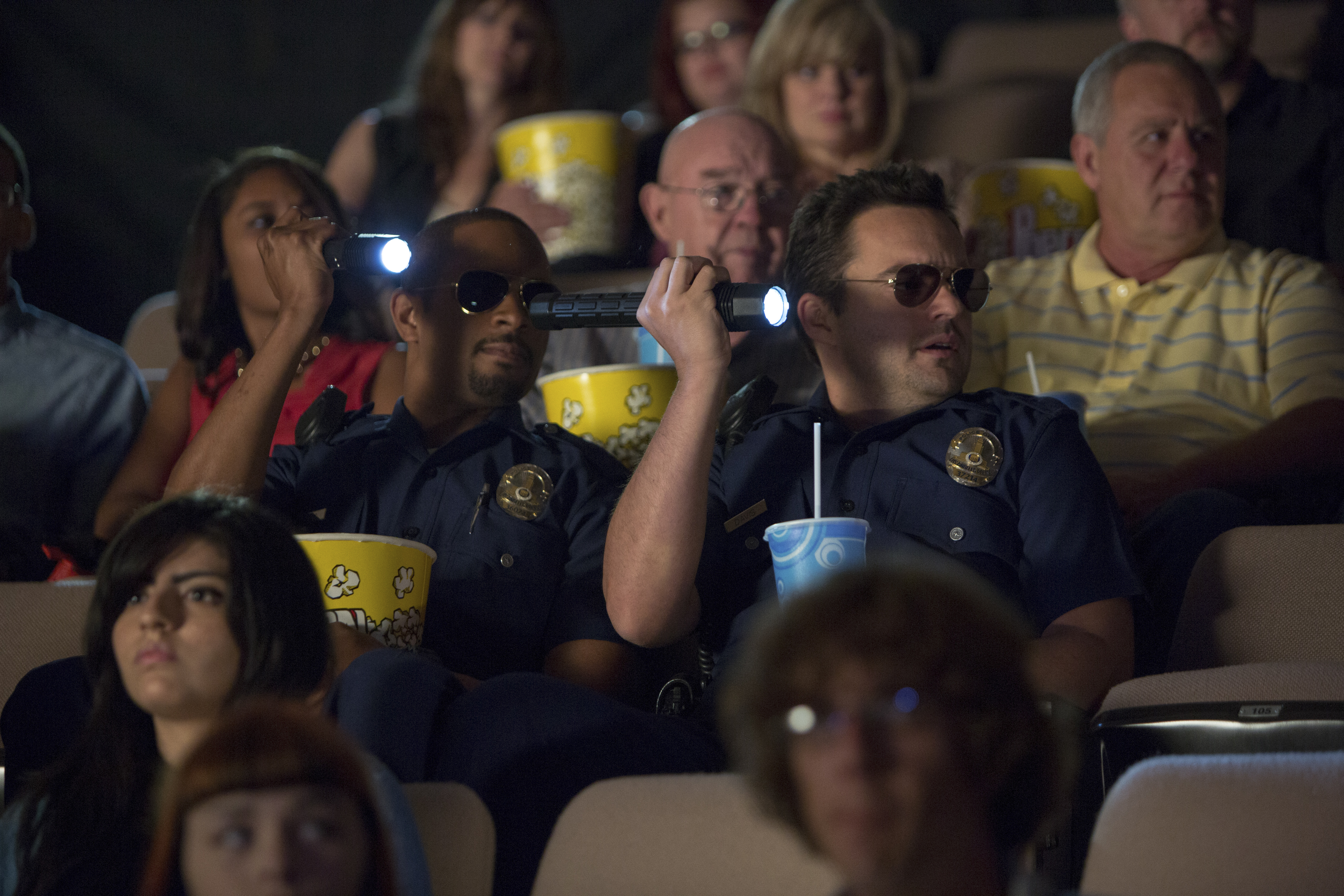 Two police officers in a movie theater HD Wallpaper