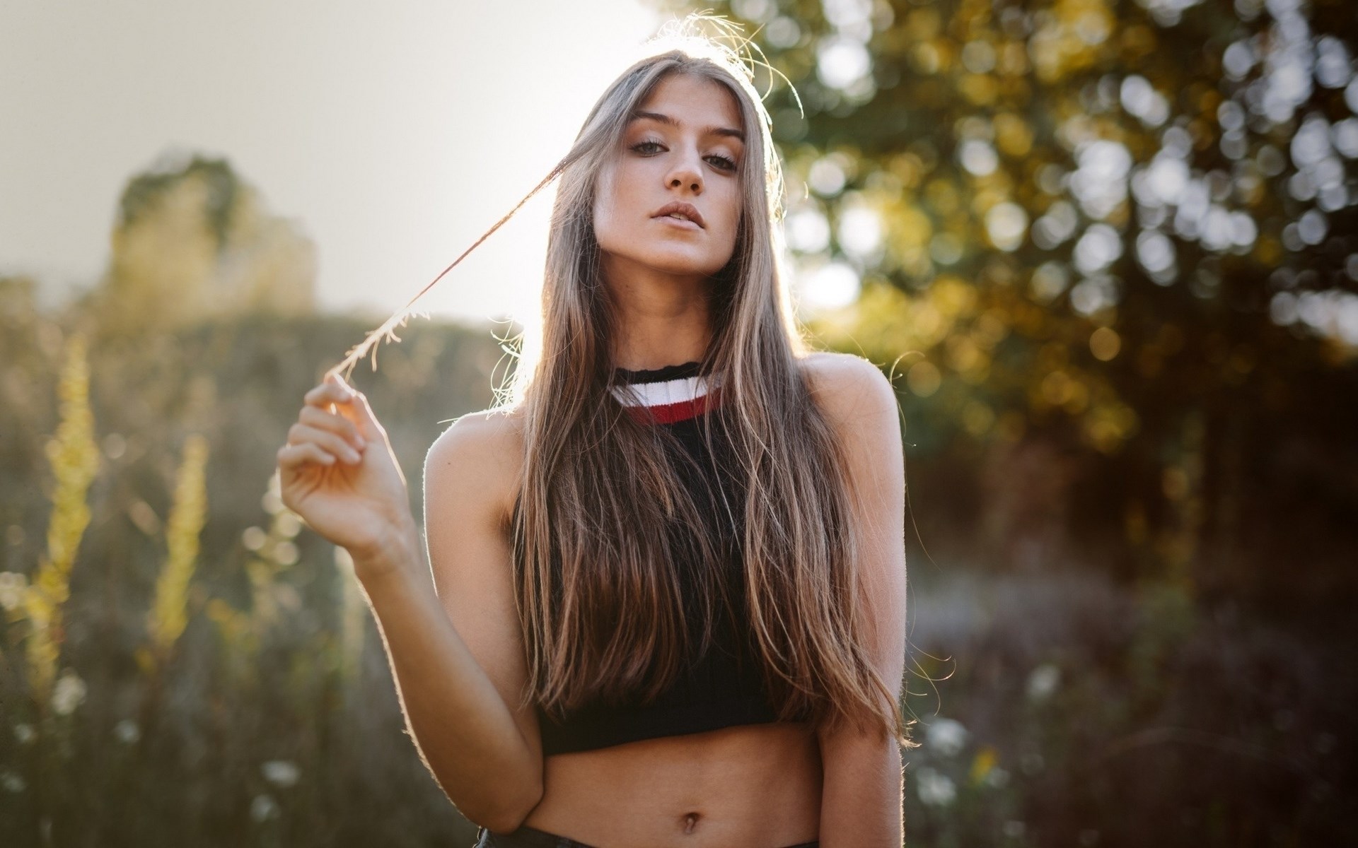 Young woman with long brown hair in a field HD Wallpaper