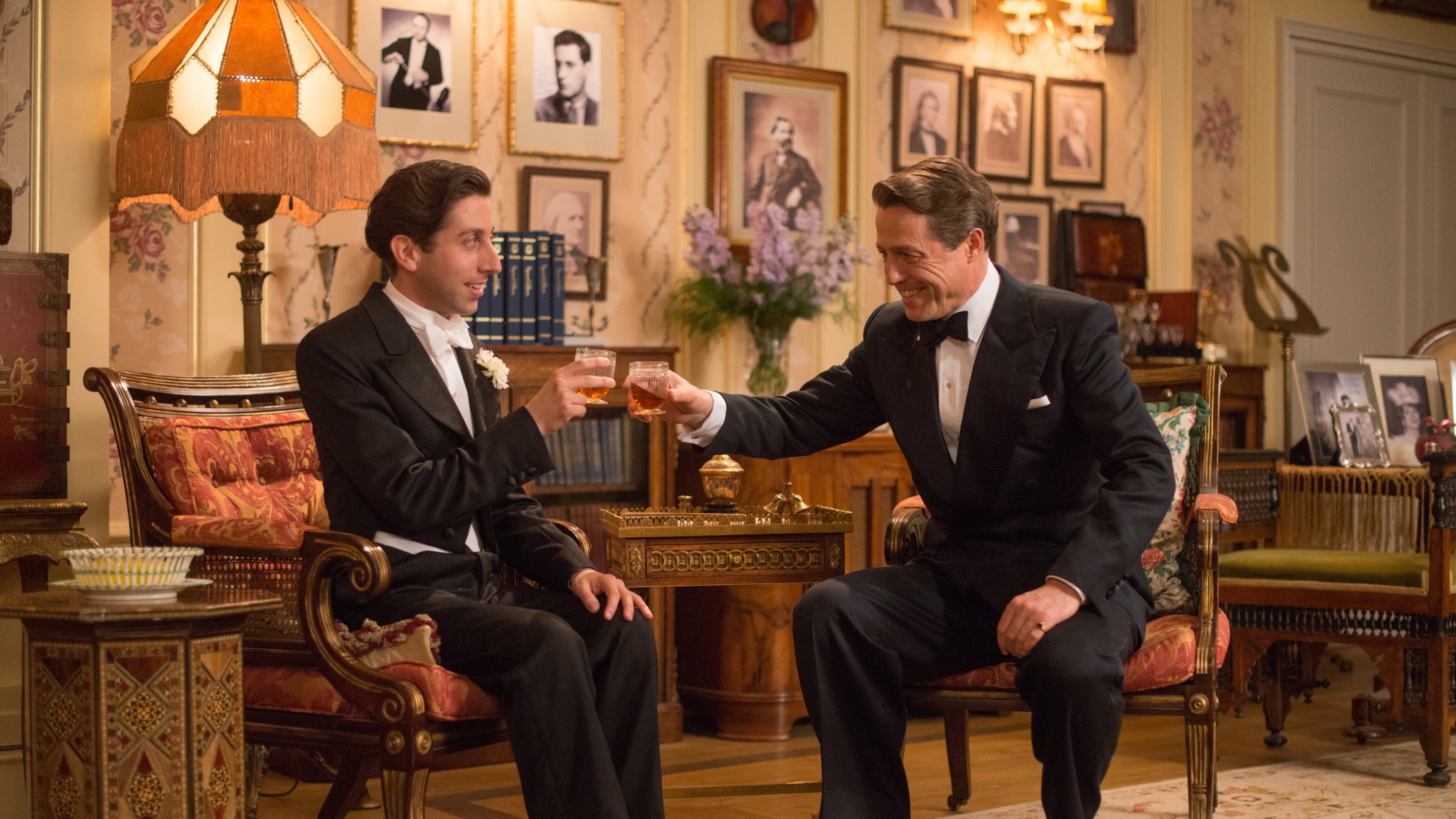 Hugh Grant and actor in suits toasting drinks HD Wallpaper
