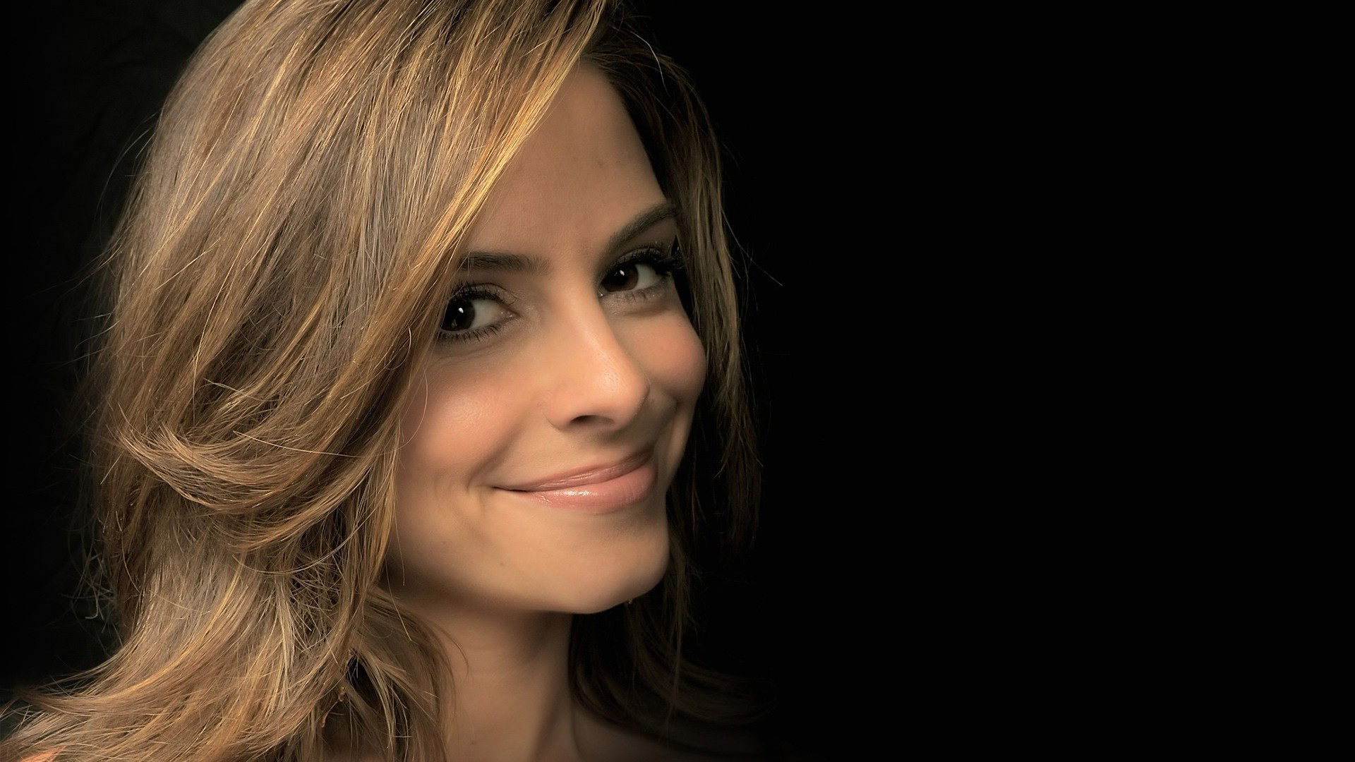 Maria Menounos smiling against a black background HD Wallpaper