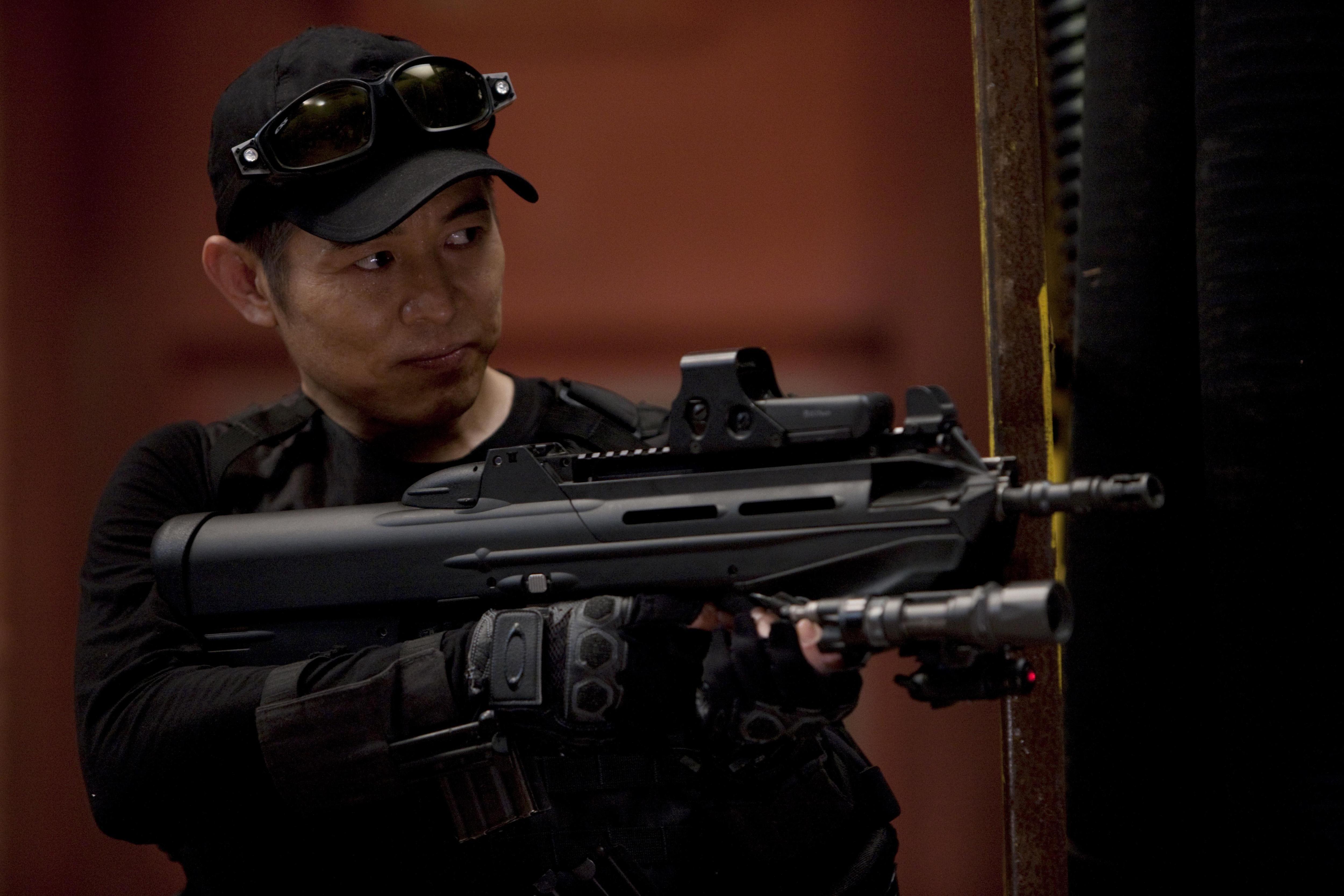Jet Li with a bullpup rifle HD Wallpaper