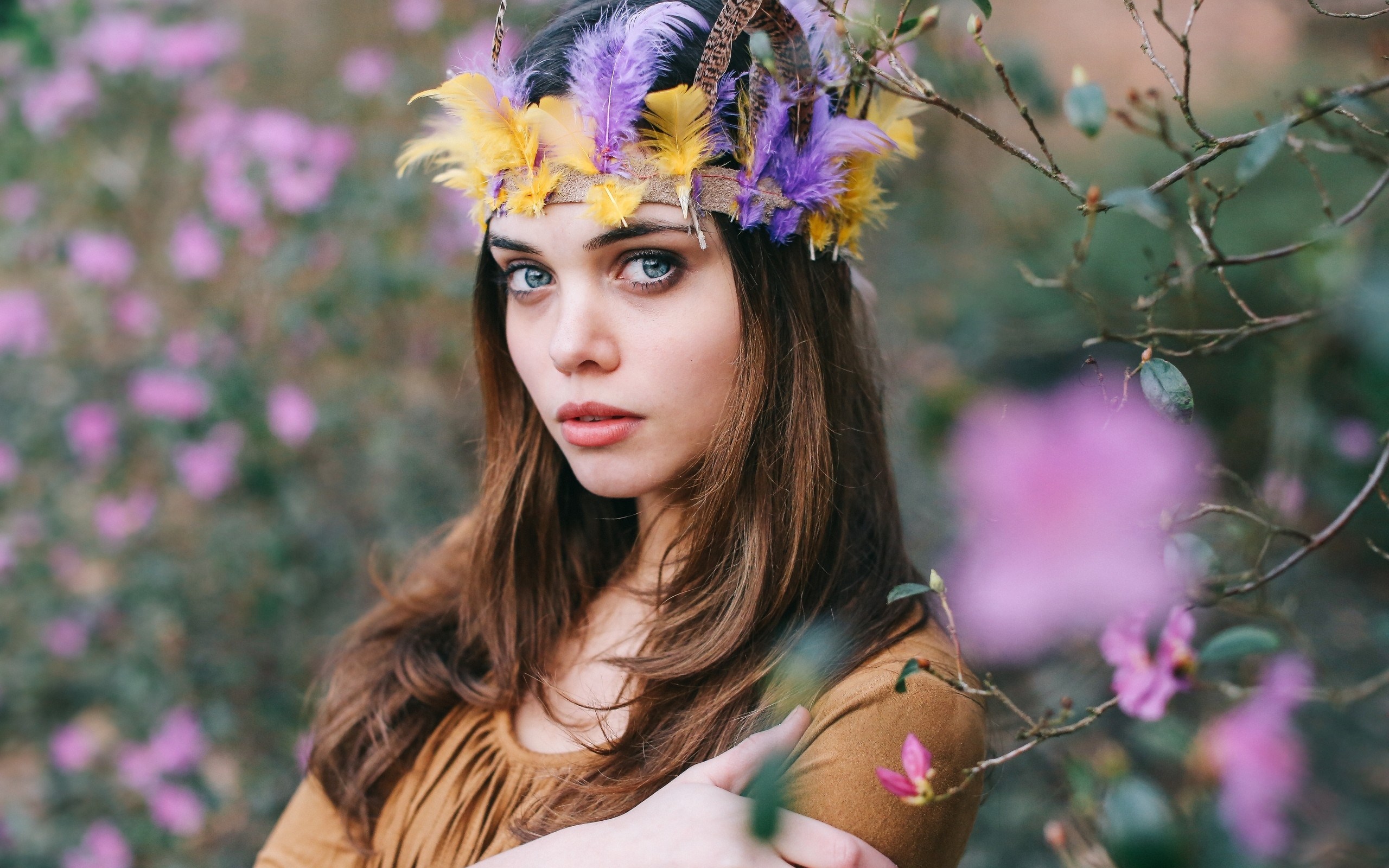 Woman with feather headdress in a garden HD Wallpaper