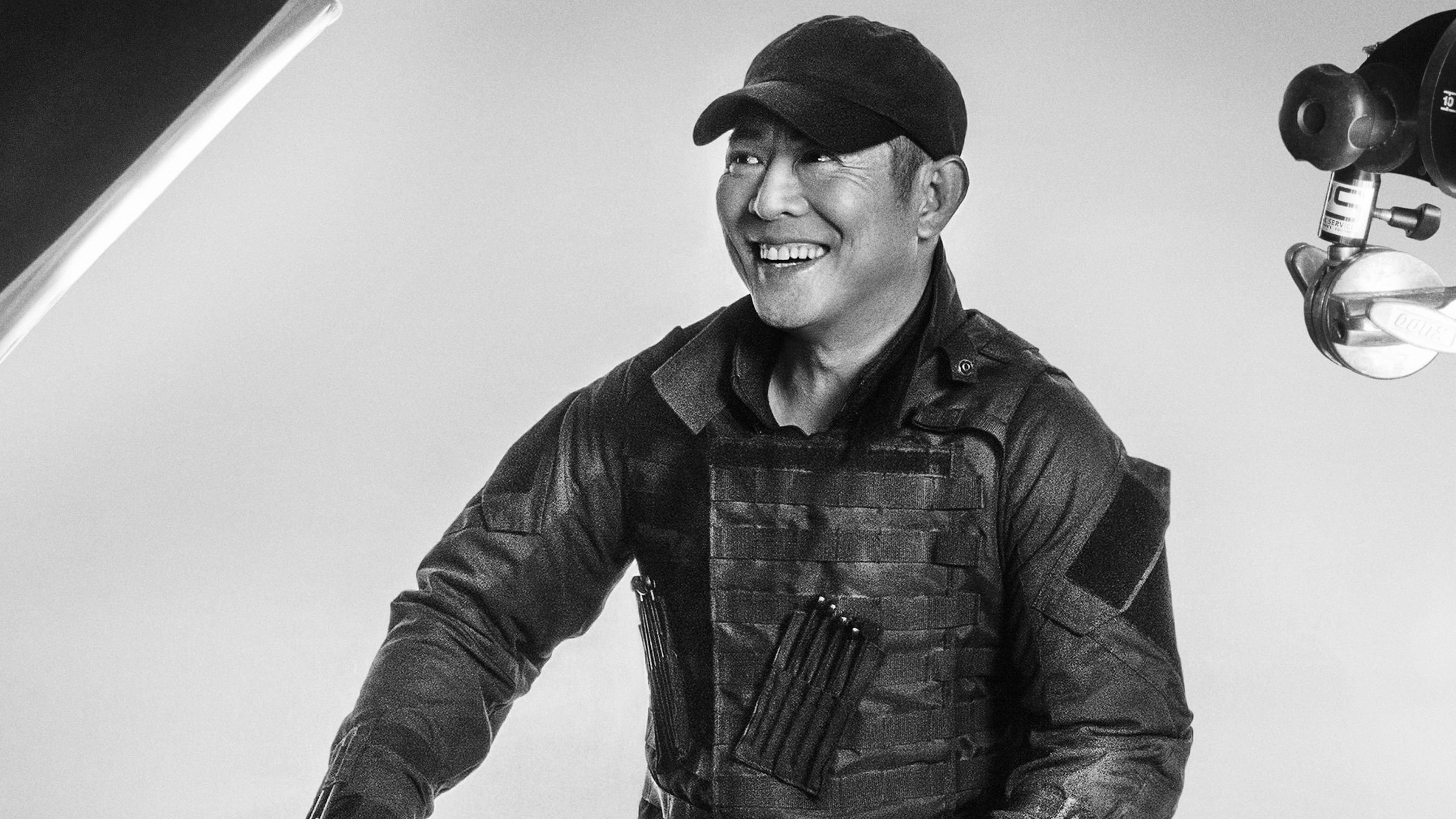 Jet Li wearing tactical gear and a baseball cap HD Wallpaper