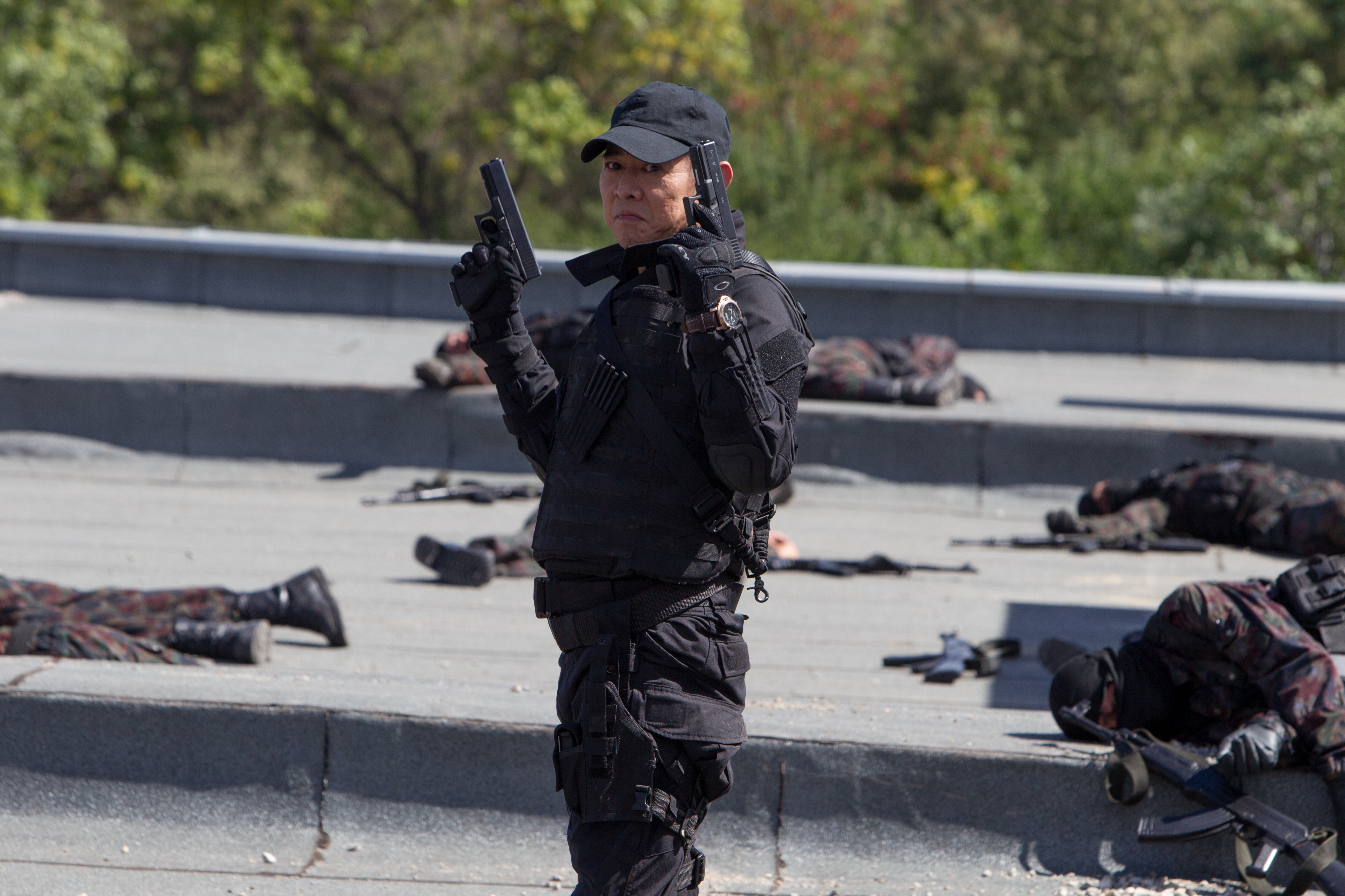 Jet Li in tactical gear holding two pistols HD Wallpaper