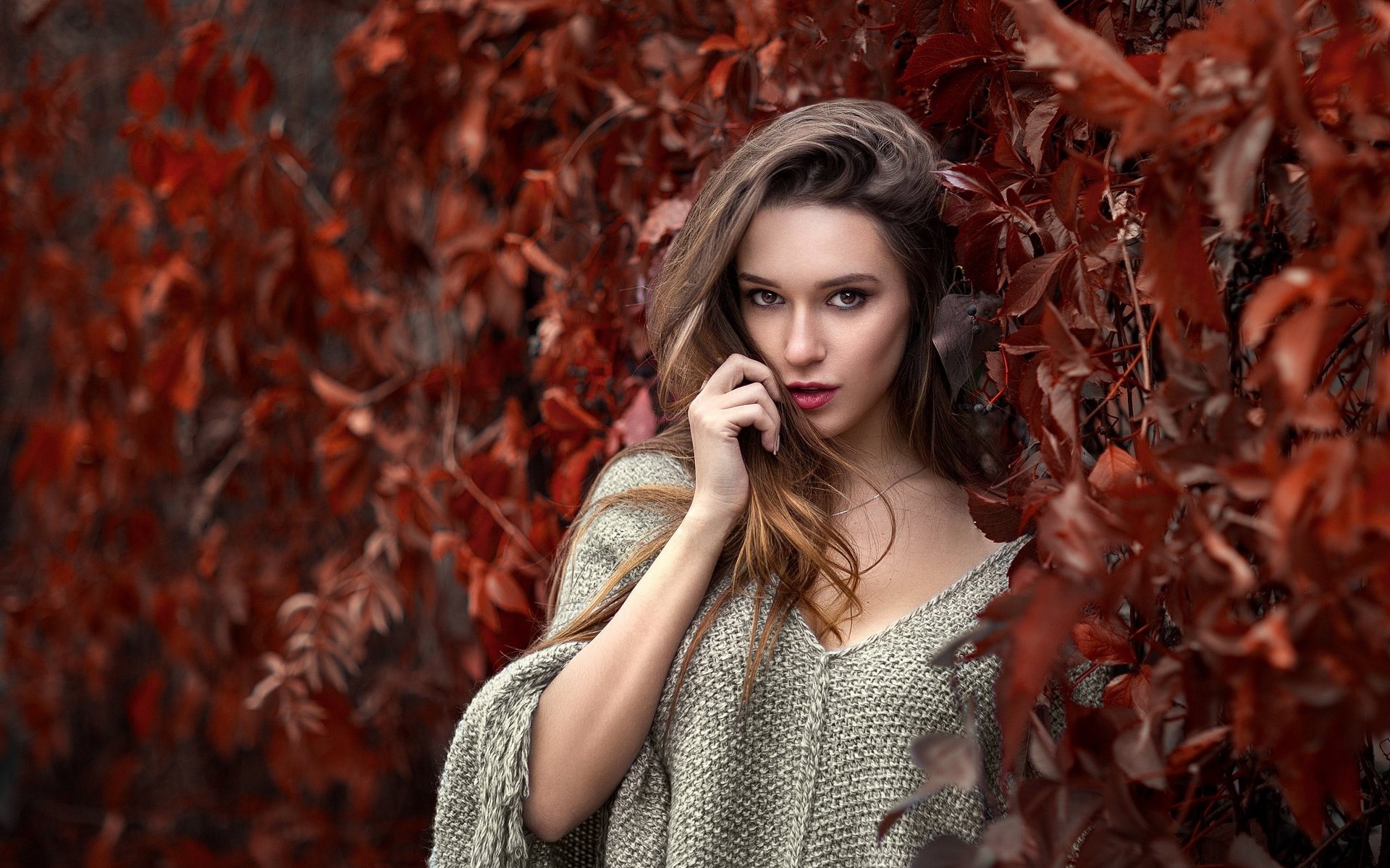 Woman in a knitted poncho among red leaves HD Wallpaper