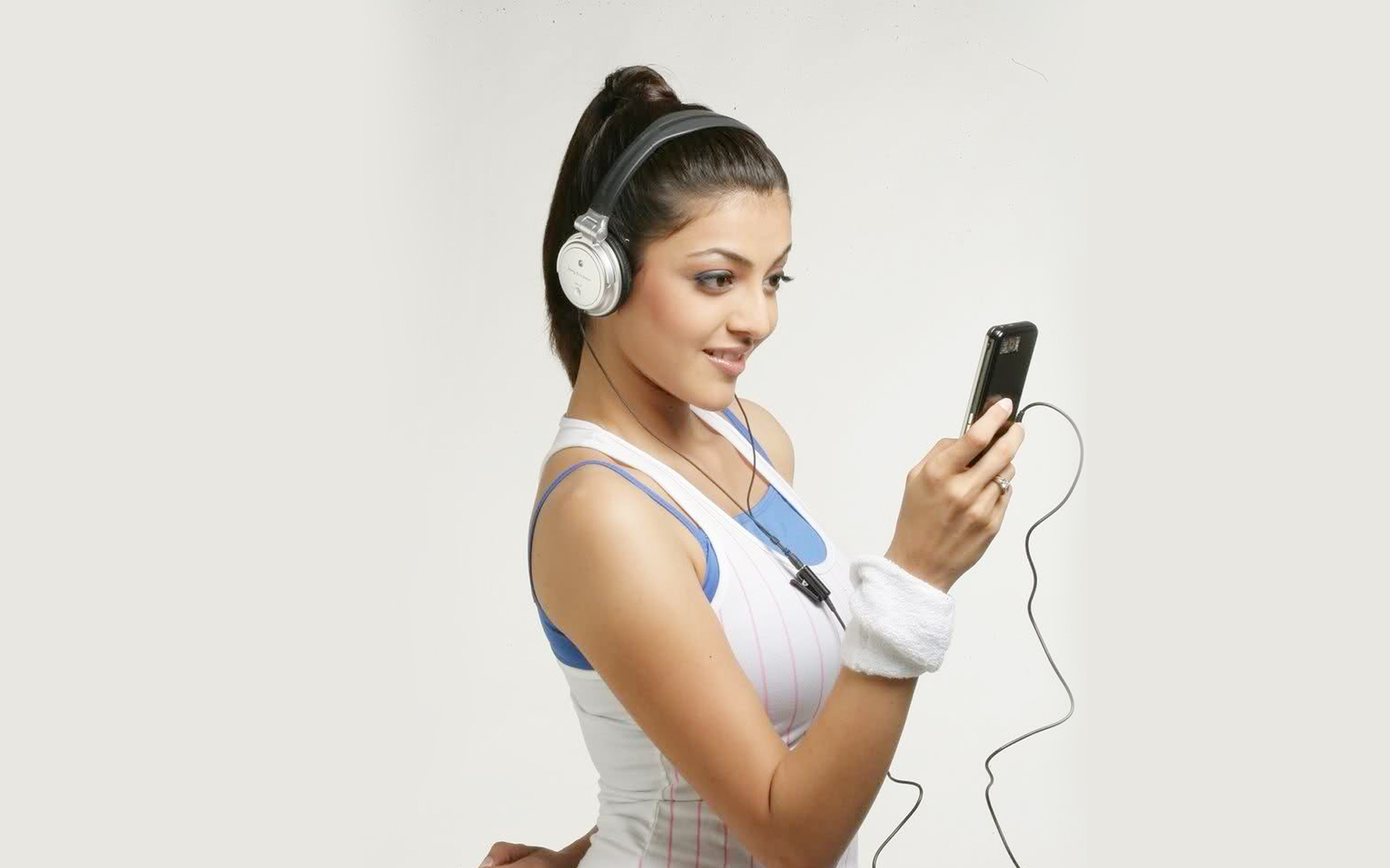 Kajal Agarwal listening to music on headphones HD Wallpaper