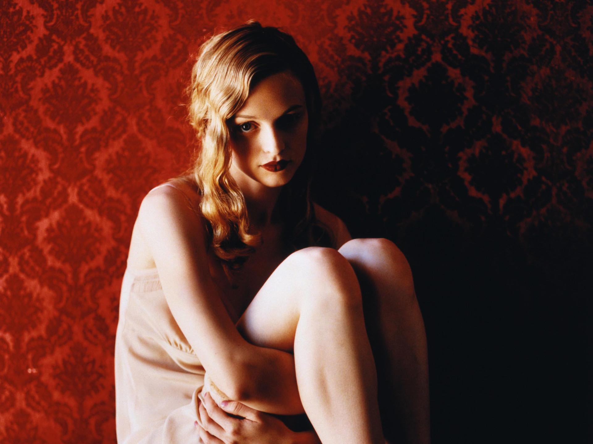 Heather Graham sitting against red damask wallpaper HD Wallpaper