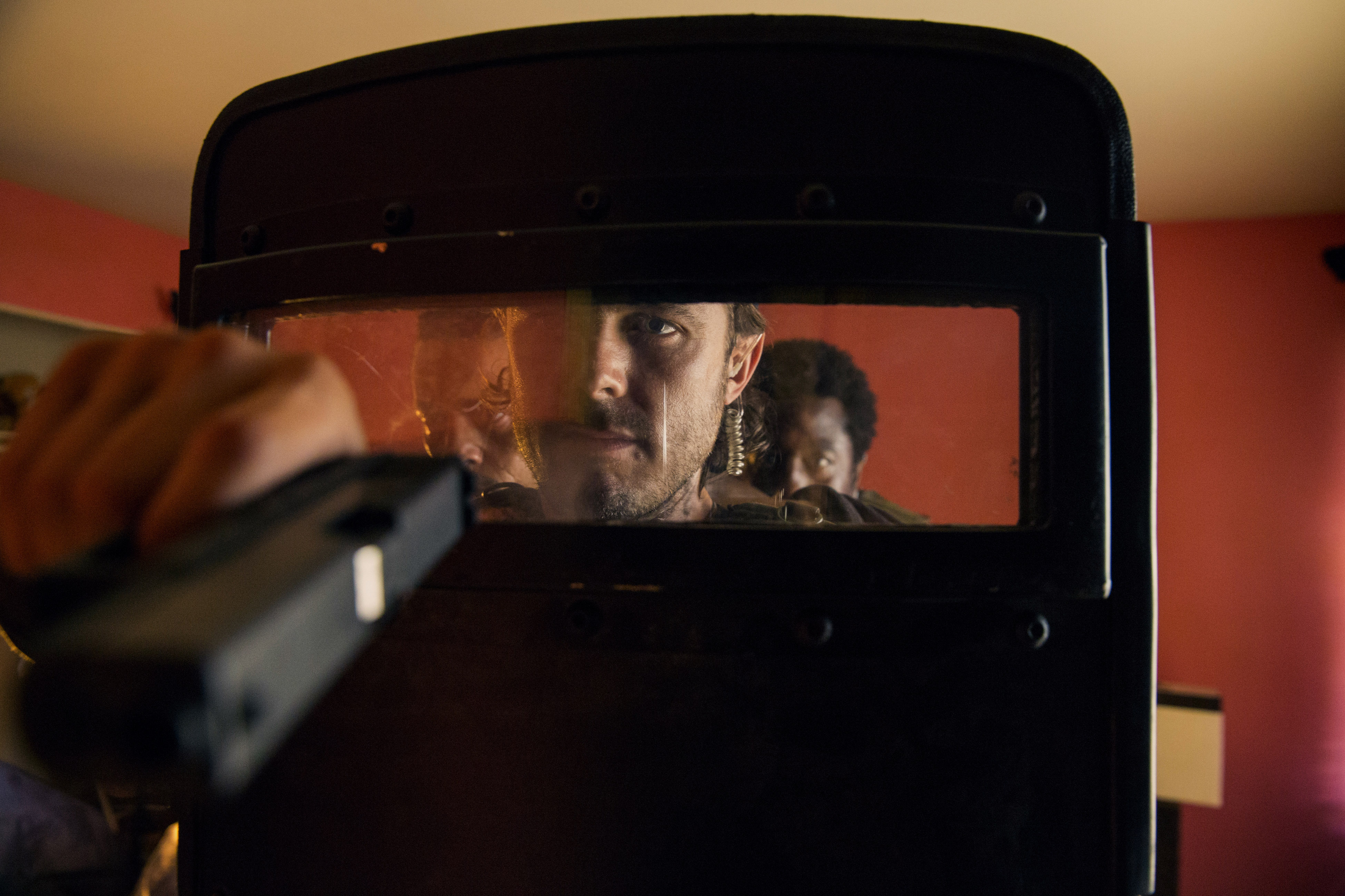 Casey Affleck and others behind a riot shield HD Wallpaper