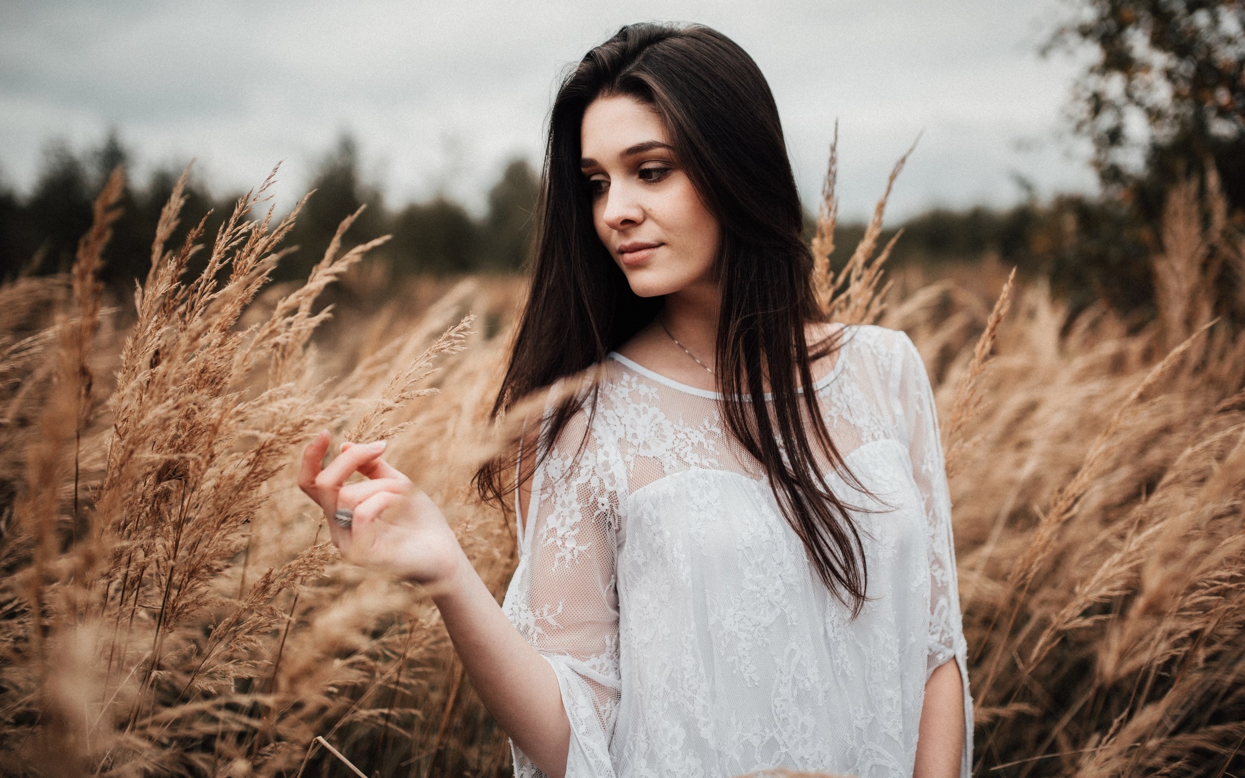 Woman in white lace dress in a field of tall grass HD Wallpaper