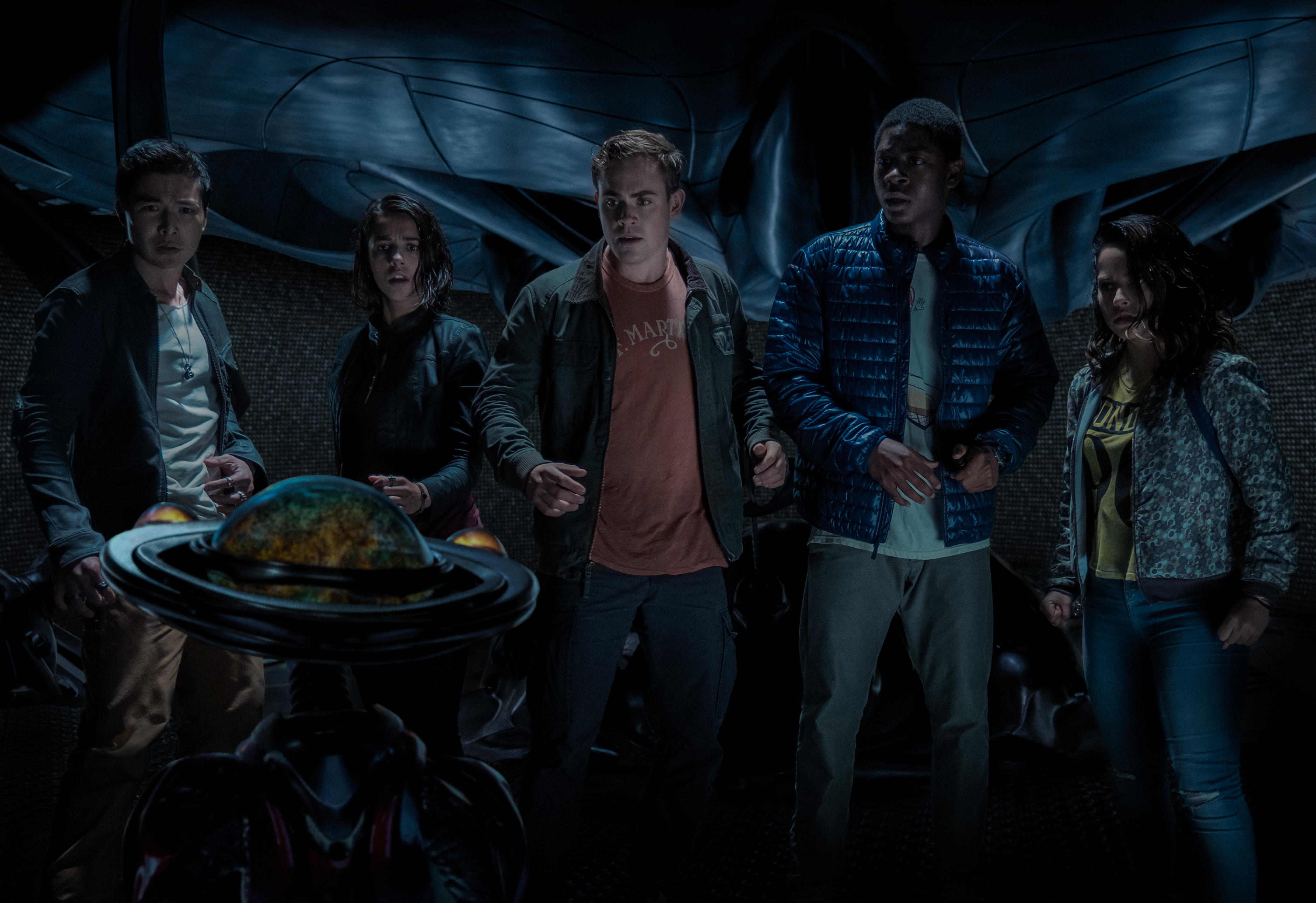 Five teenagers look at a globe in a dark room HD Wallpaper