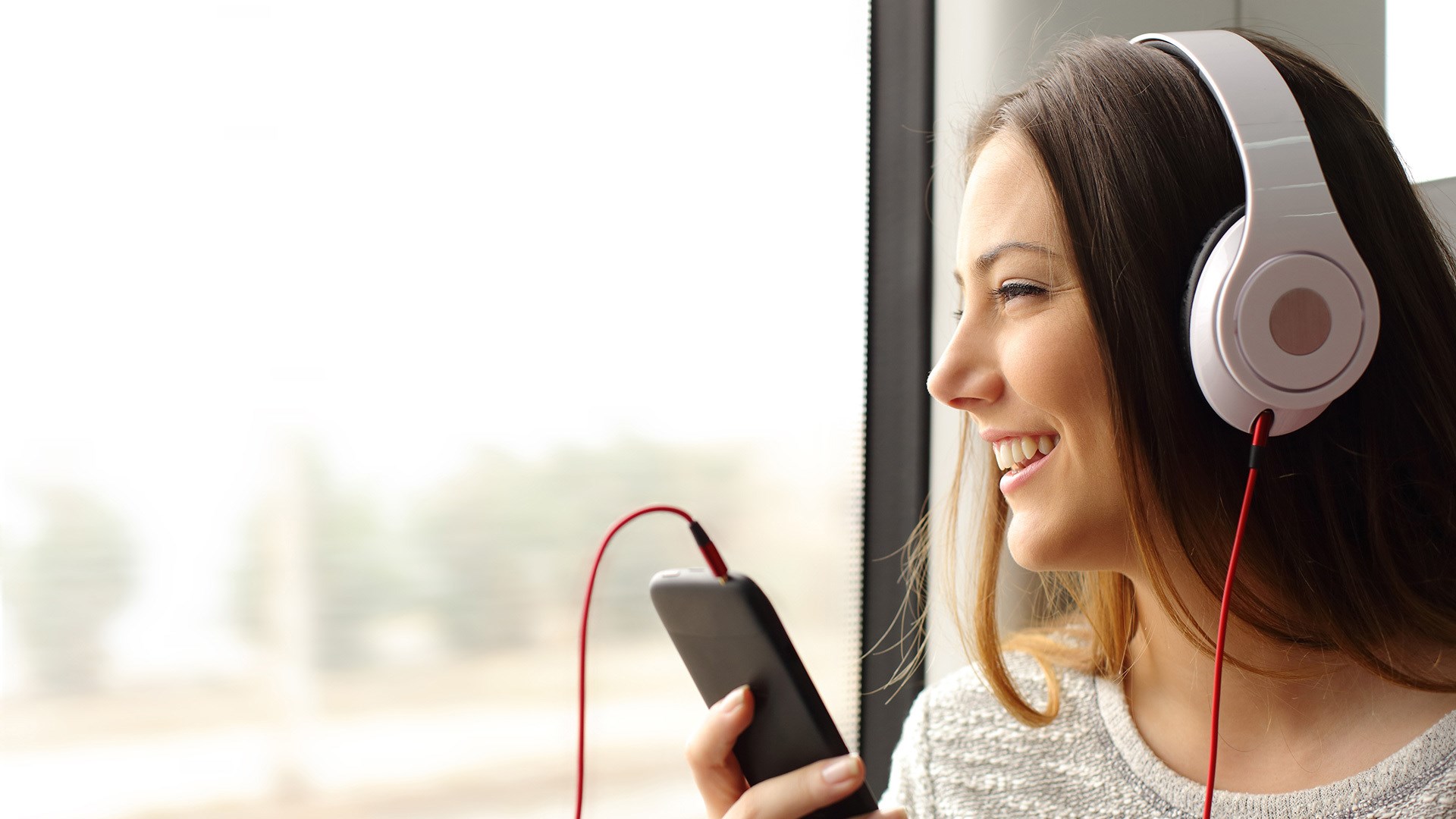Woman listening to music on phone with headphones HD Wallpaper