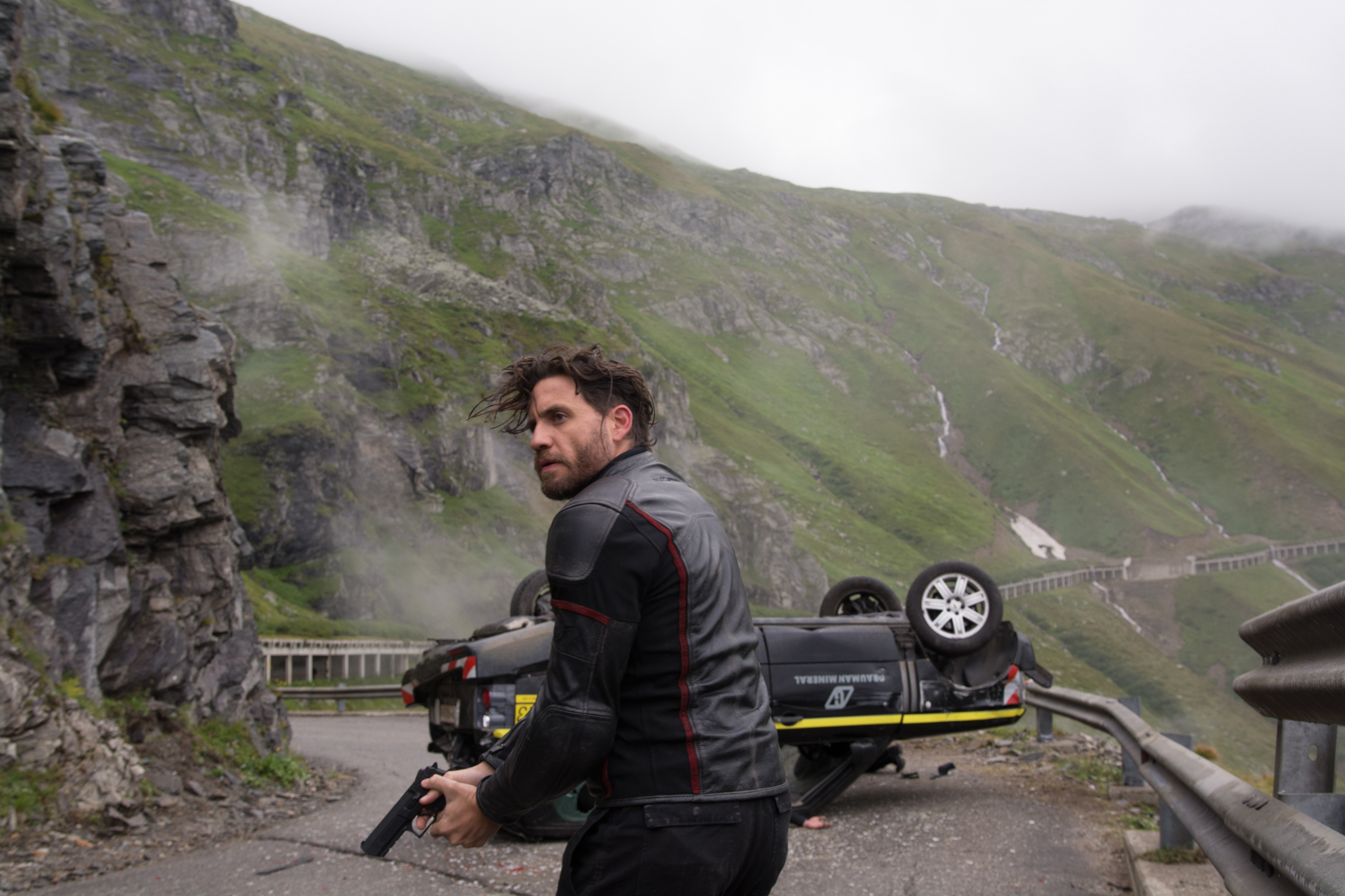 Edgar Ramirez with a gun on a mountain road HD Wallpaper