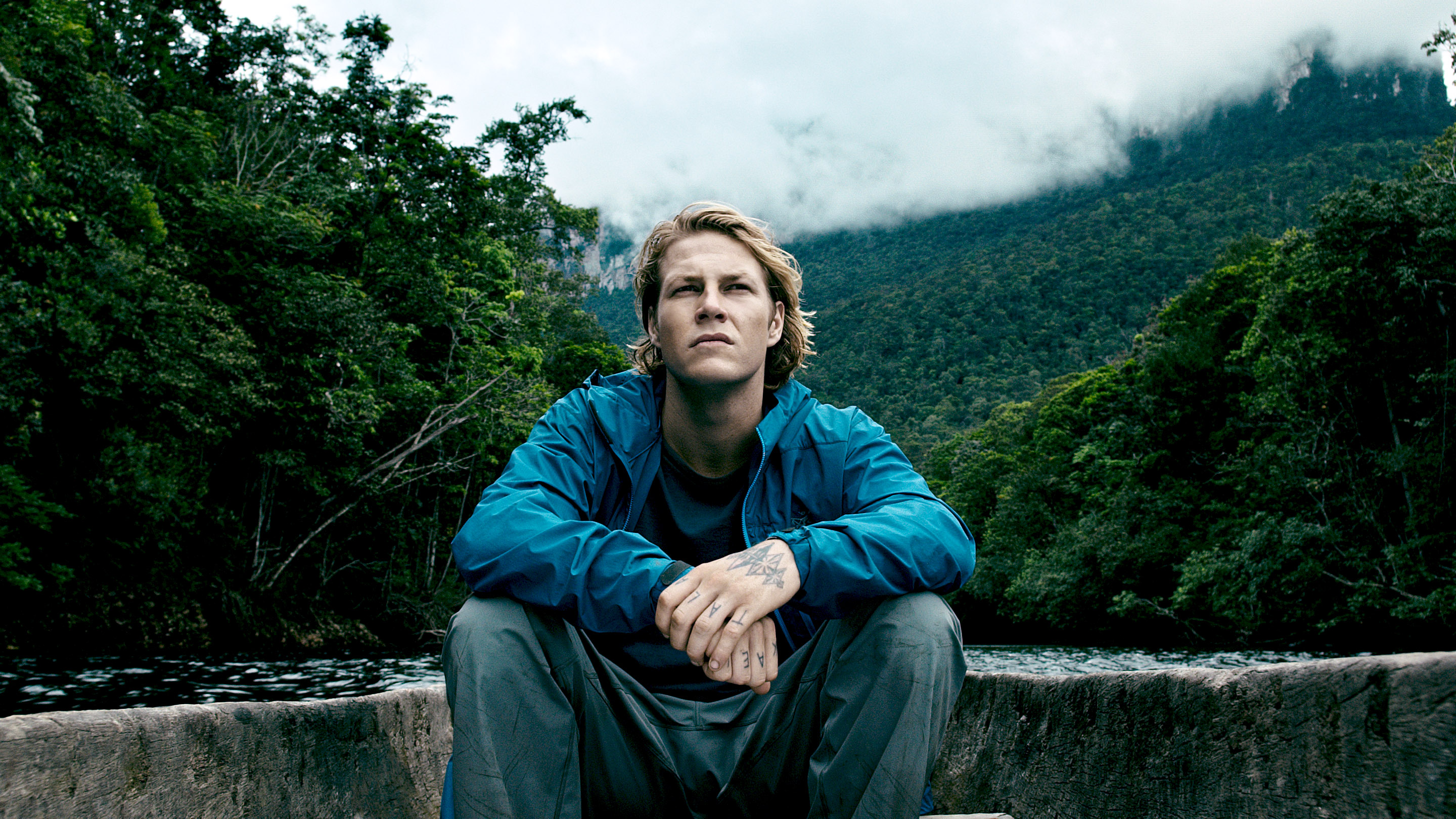 Luke Bracey in a boat on a river HD Wallpaper
