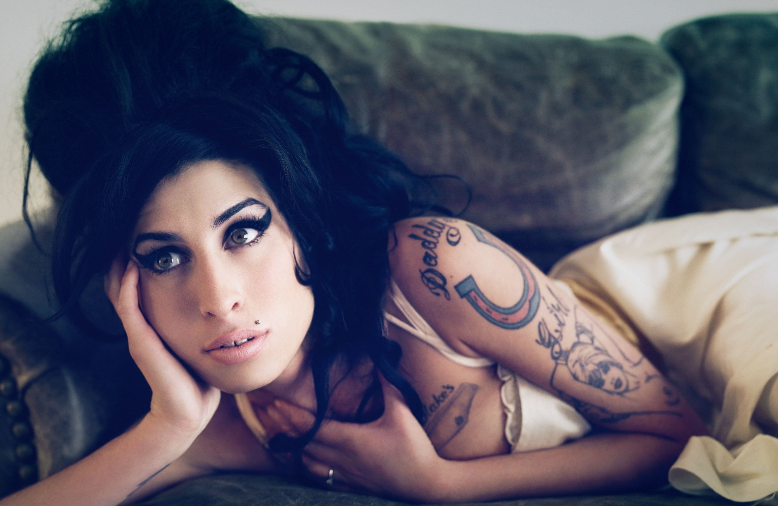 Amy Winehouse lying on a couch HD Wallpaper