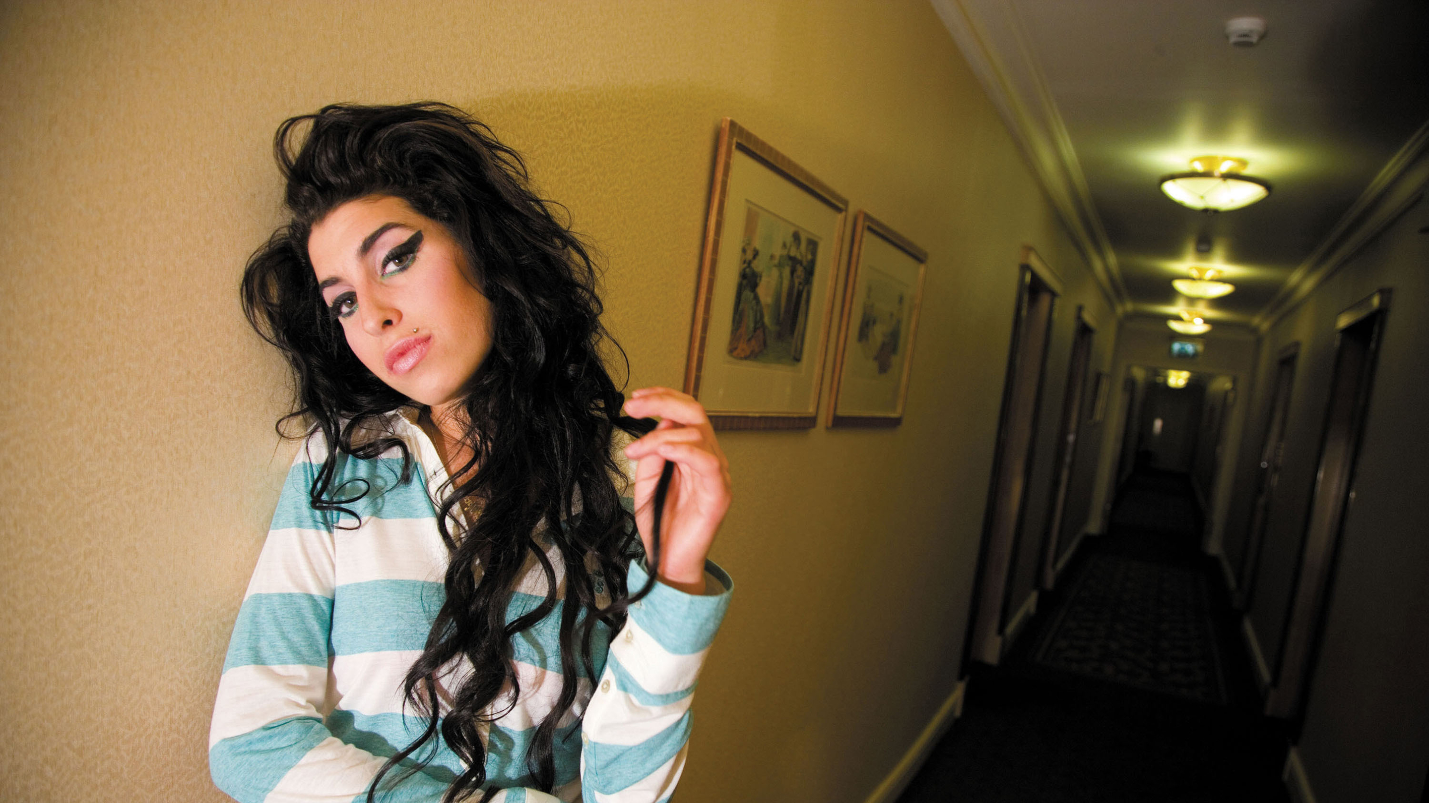 Amy Winehouse in a hotel hallway HD Wallpaper