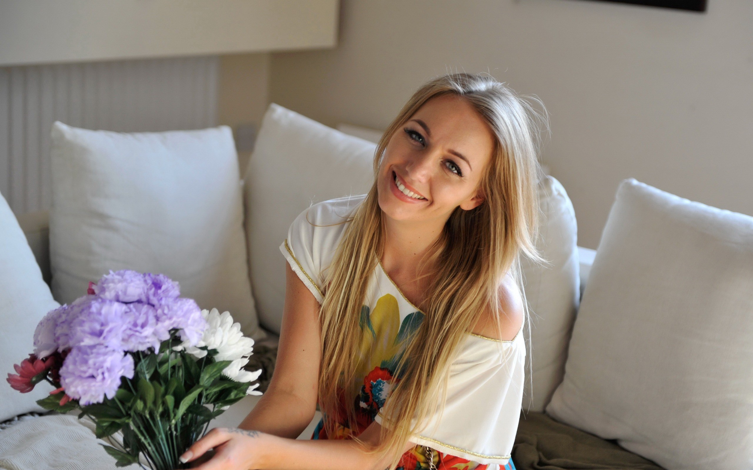 Woman holding flowers on a couch HD Wallpaper