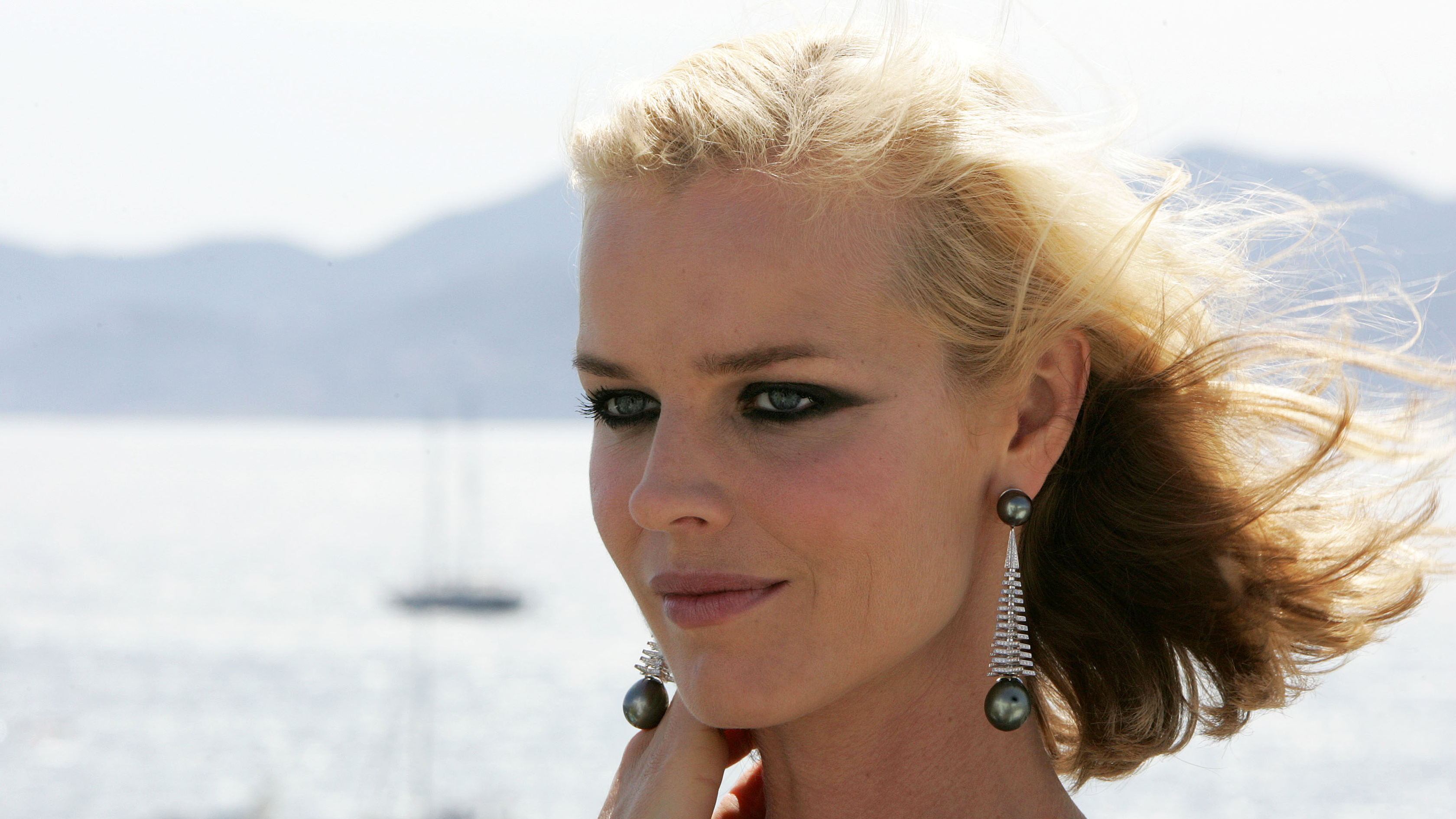 Eva Herzigova on a boat with mountains in the background HD Wallpaper