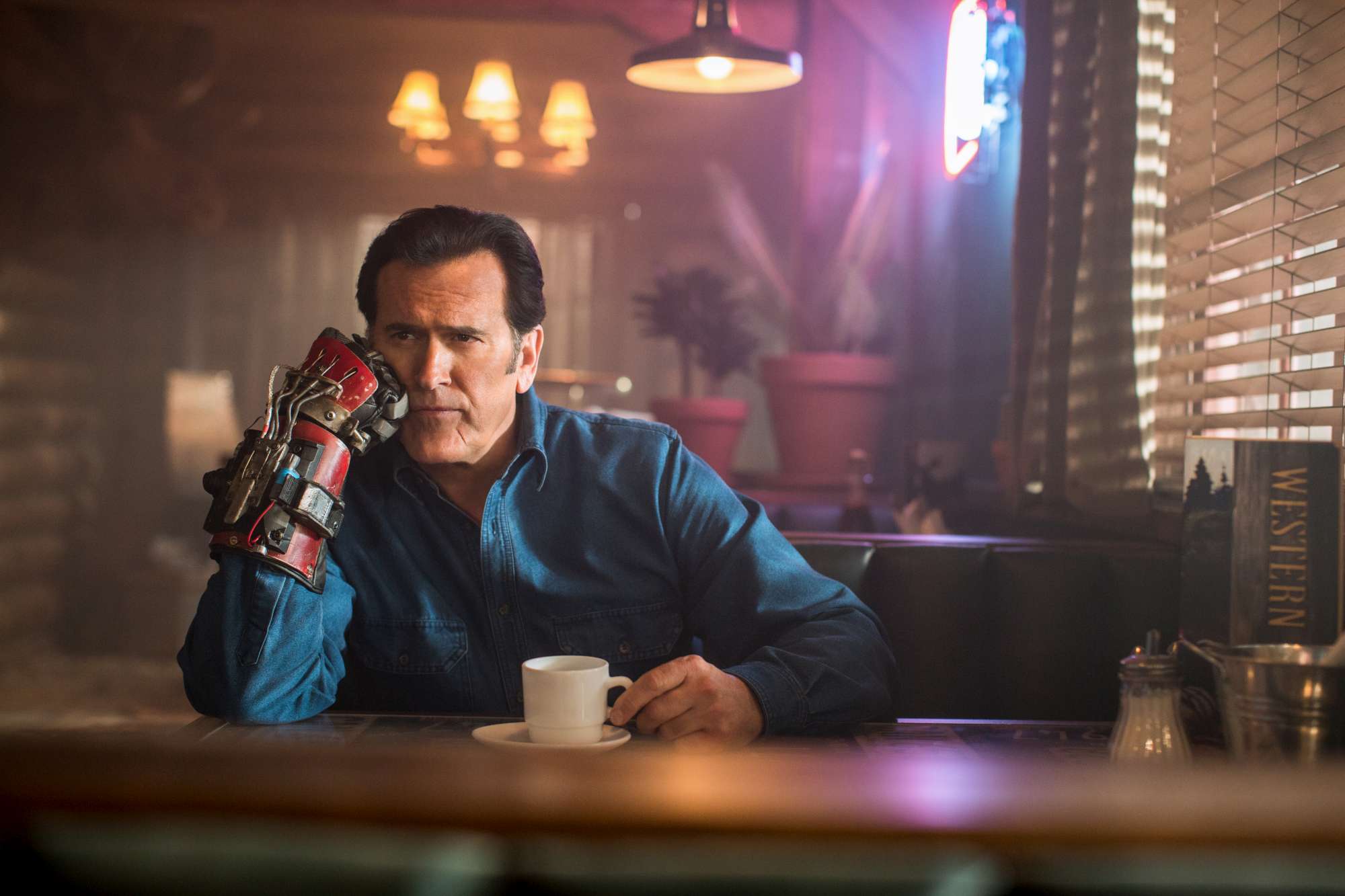 Bruce Campbell with robotic arm in diner HD Wallpaper