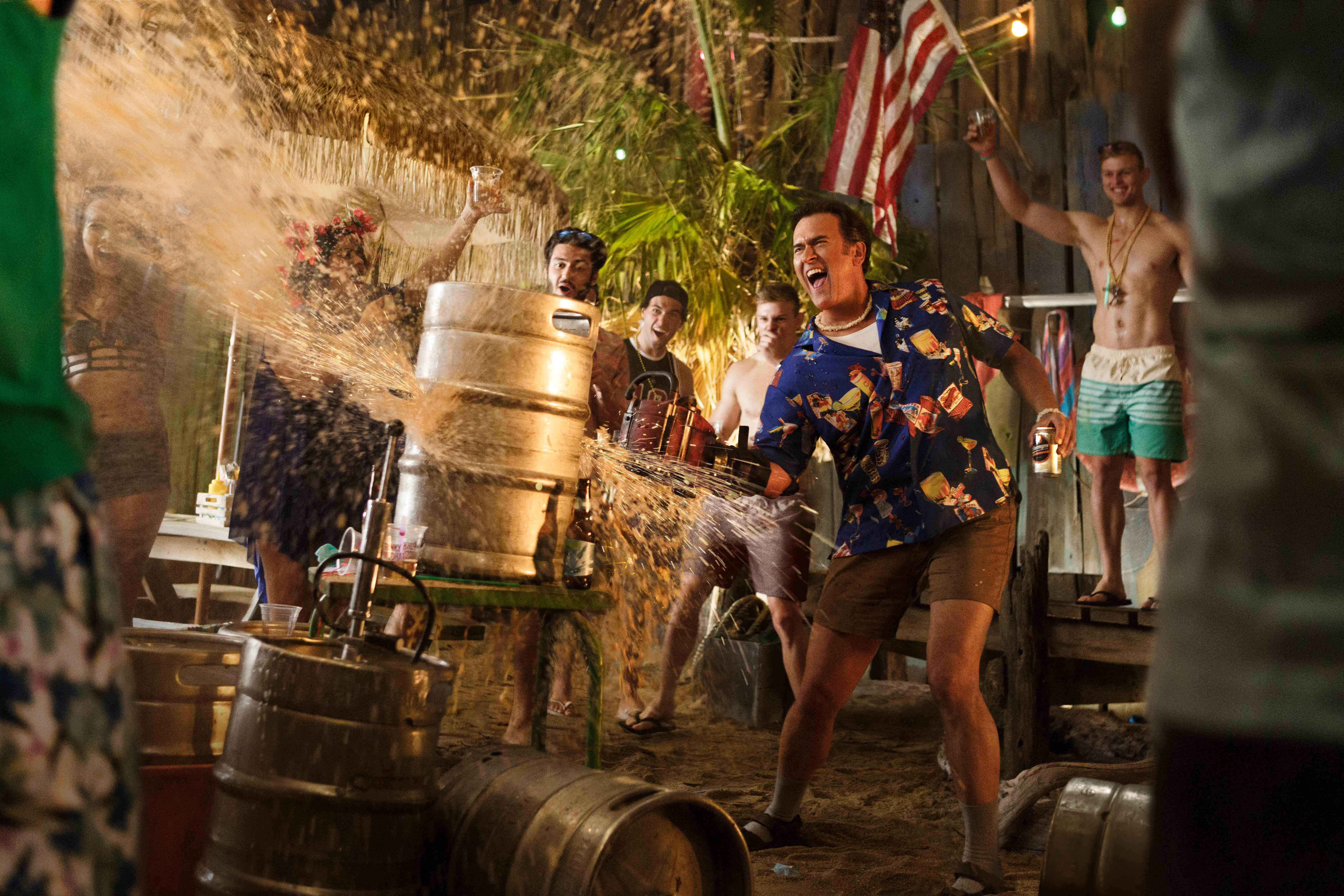 Bruce Campbell spraying beer from a keg at a party HD Wallpaper