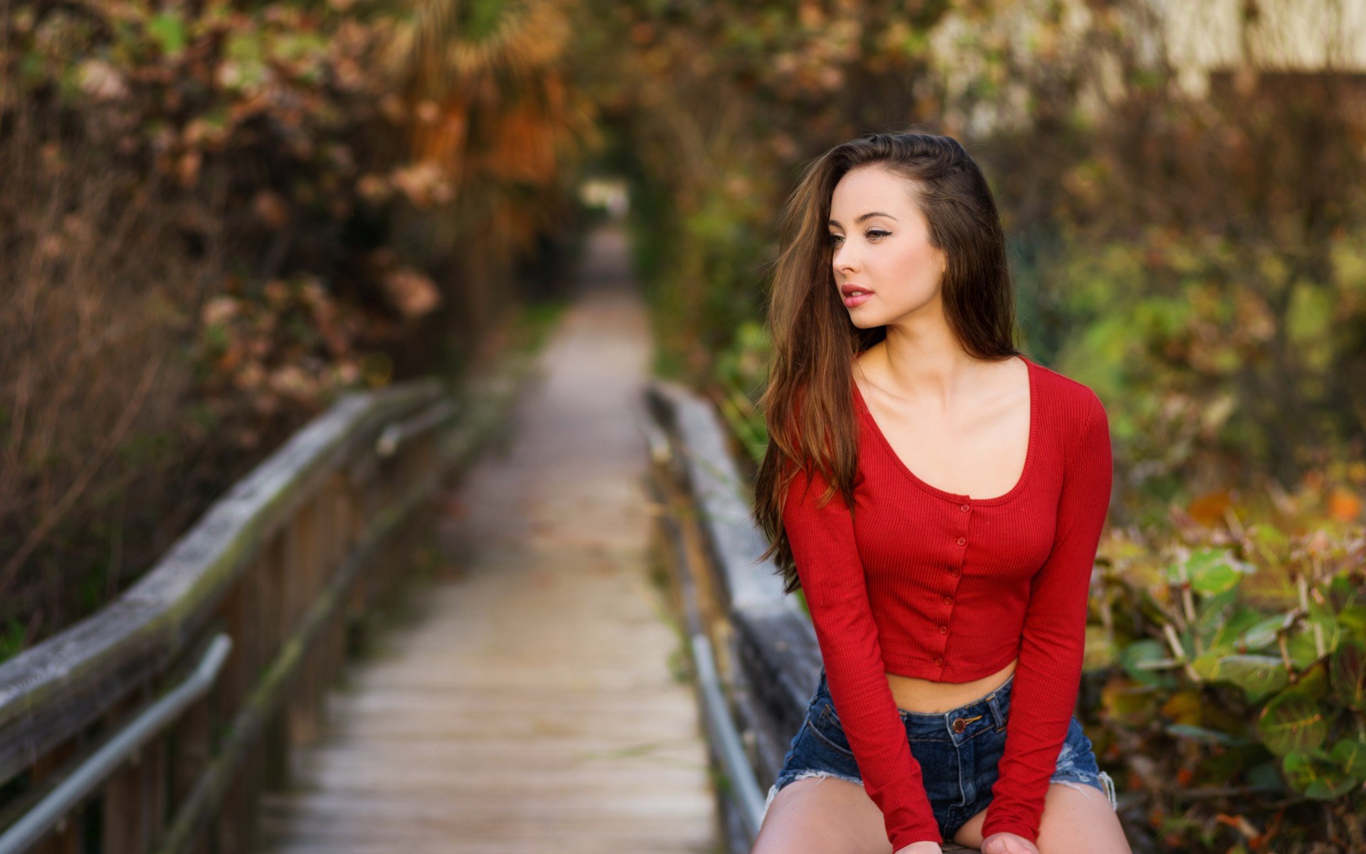 Woman in red top and denim shorts on a wooden walkway HD Wallpaper