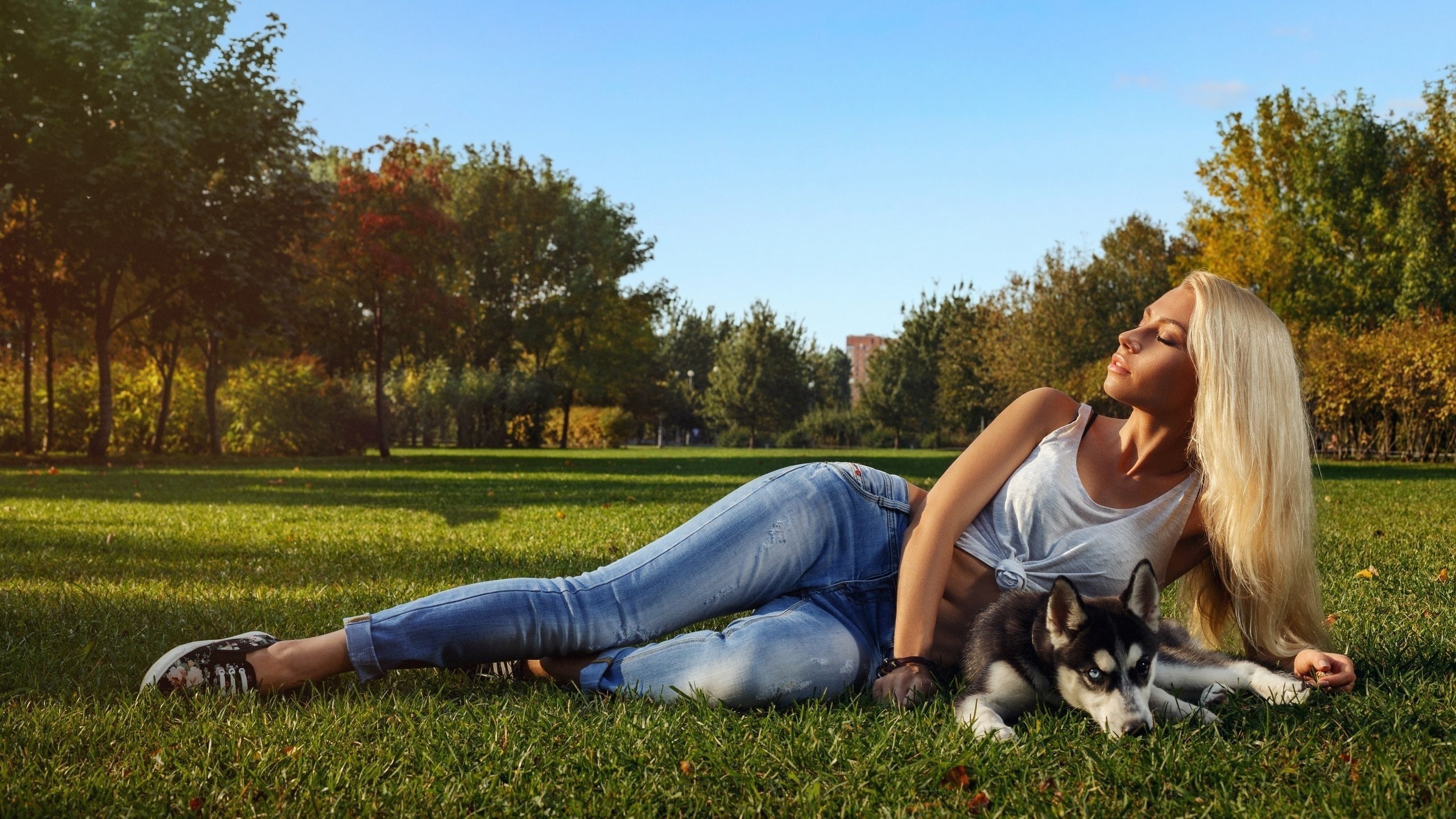 Woman and husky puppy lying on grass in park HD Wallpaper