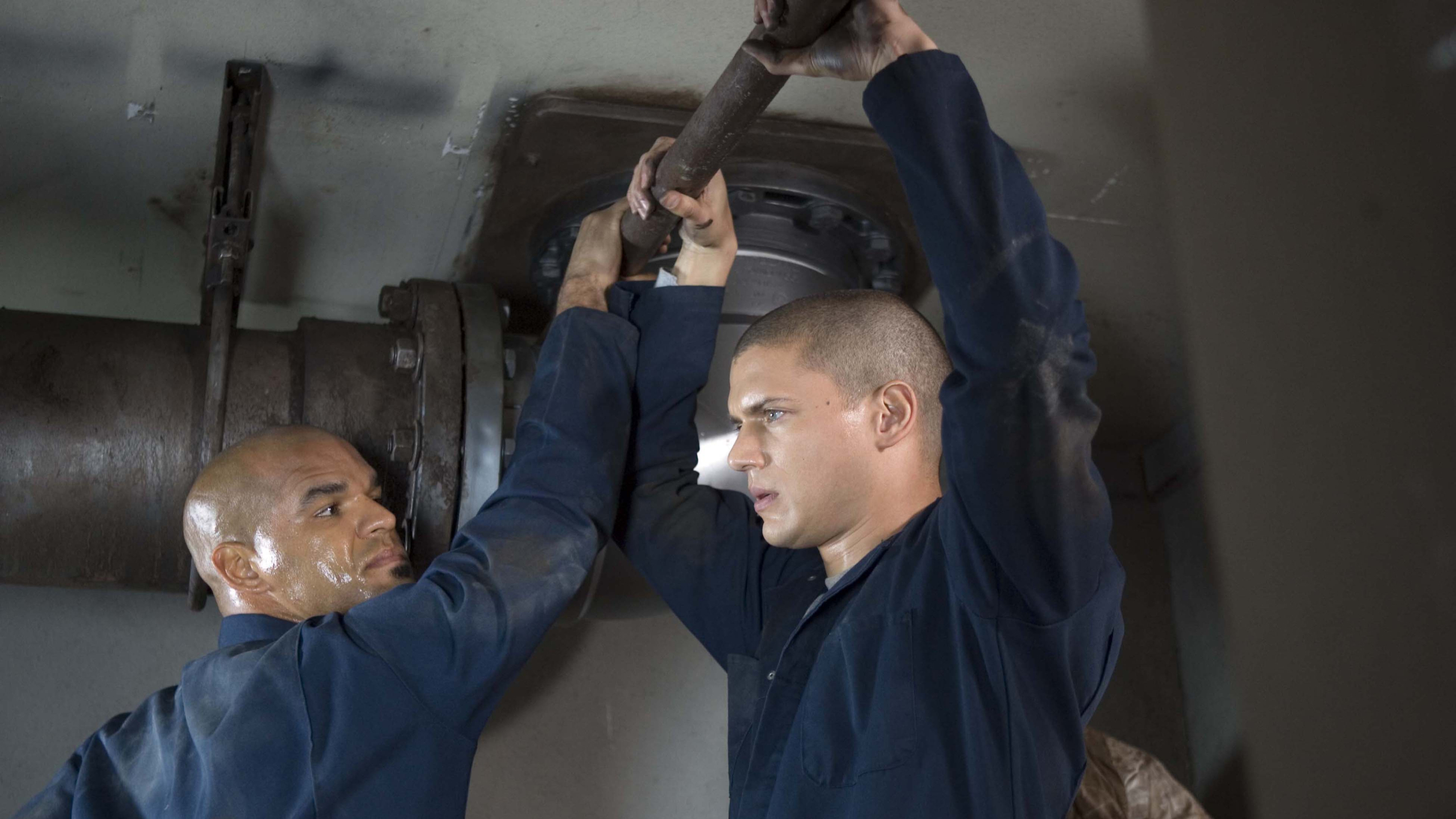Two men working on pipes HD Wallpaper