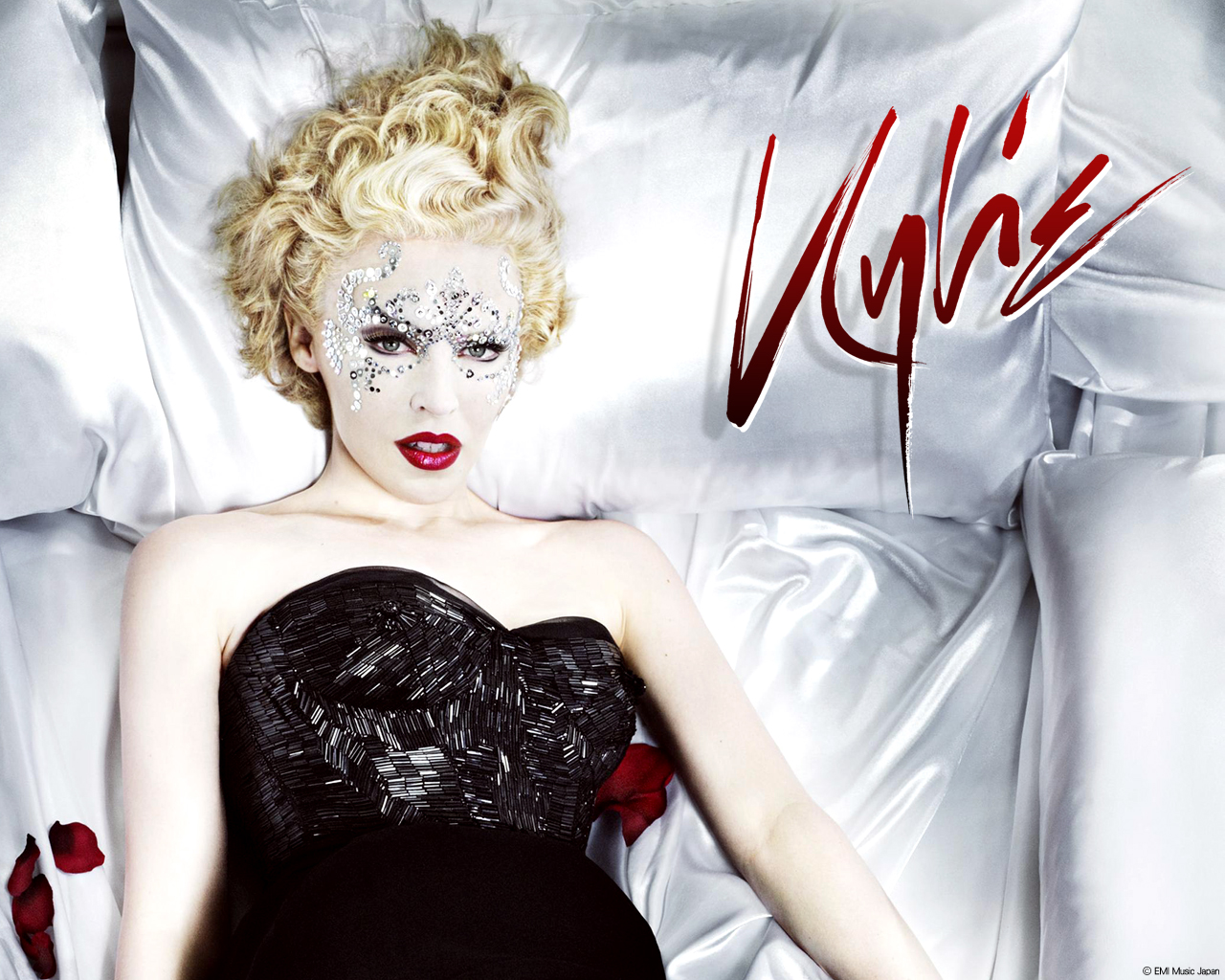 Kylie Minogue lying on pillows HD Wallpaper