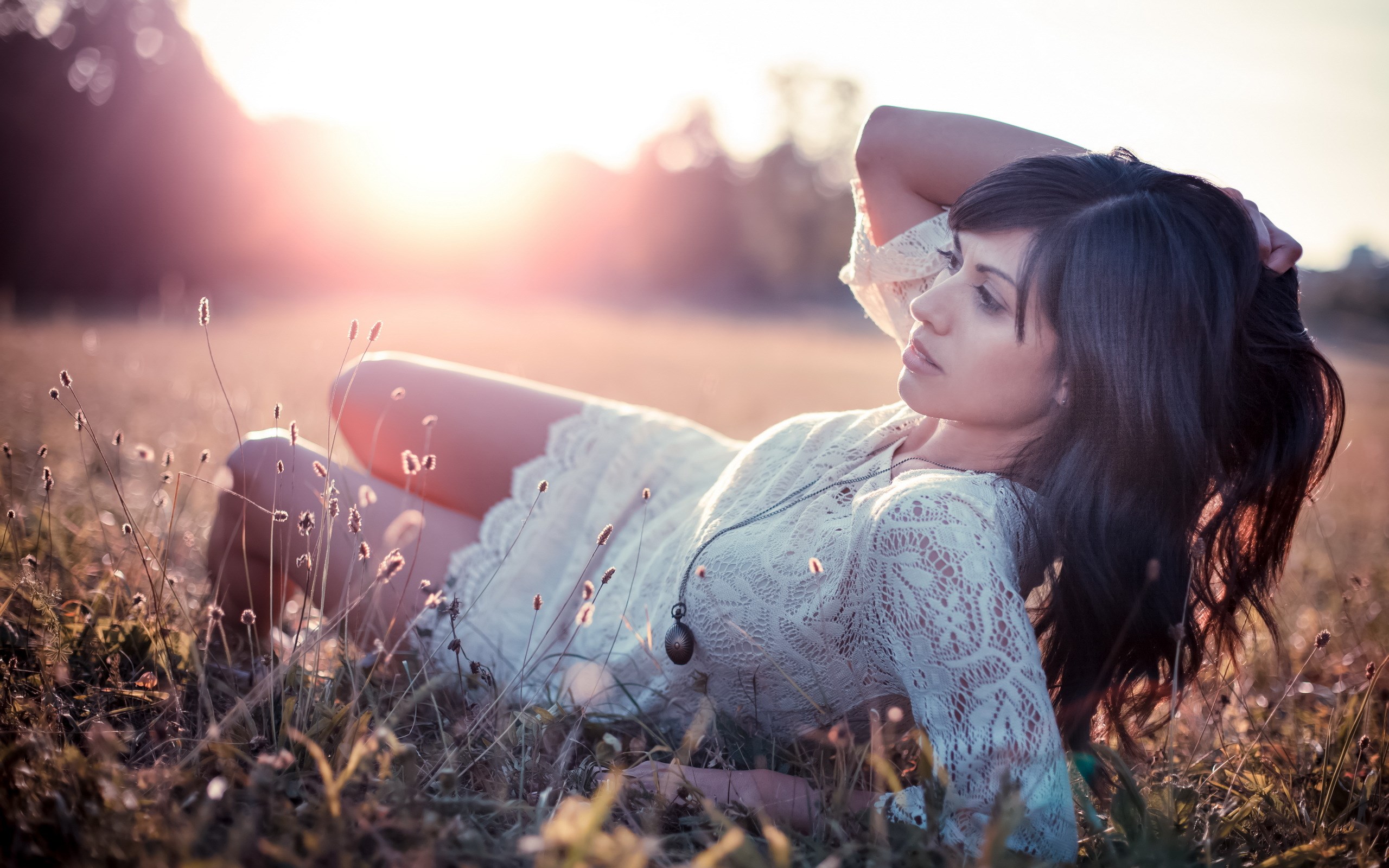 Woman lying in a field at sunset HD Wallpaper