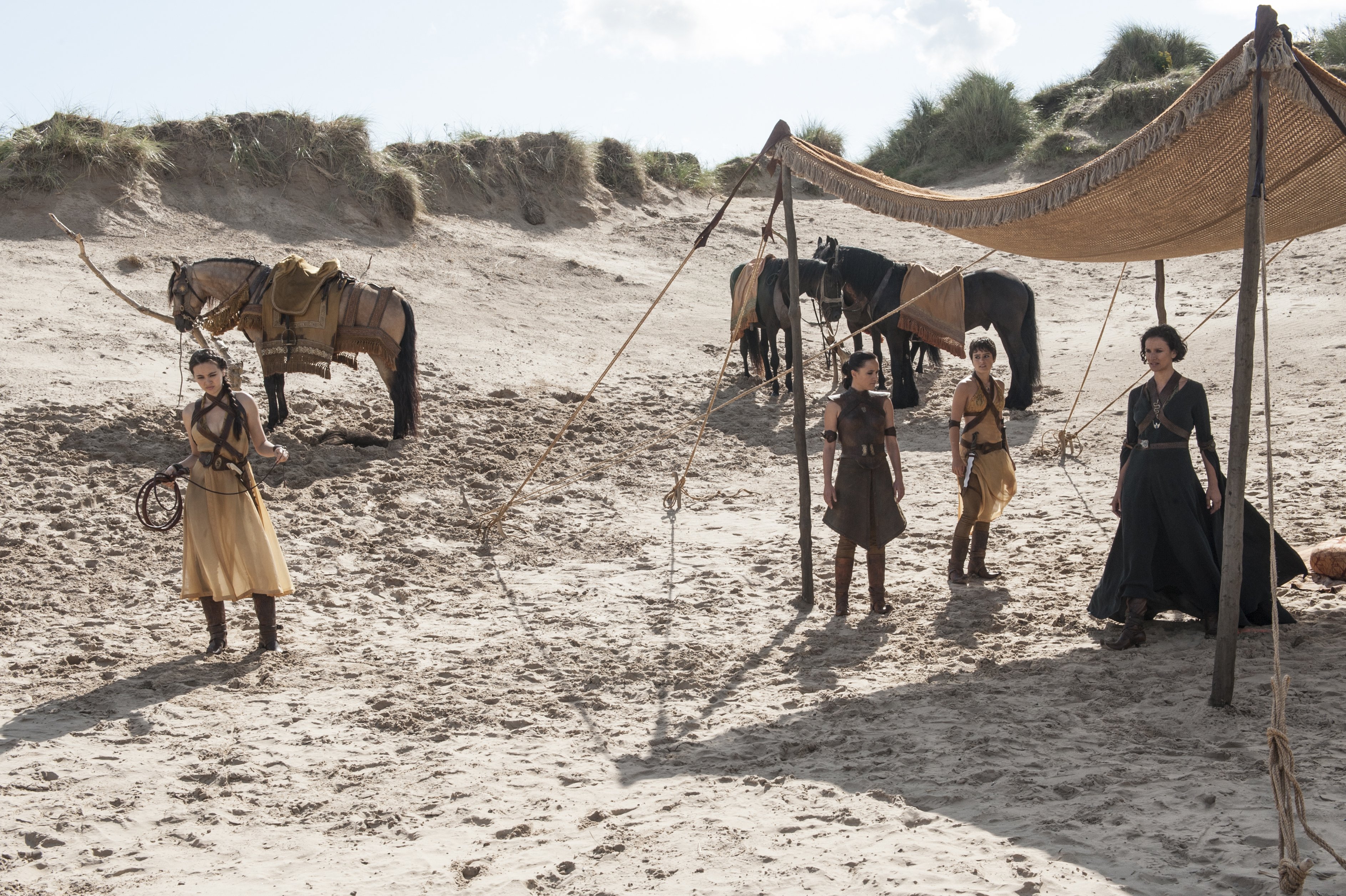 Indira Varma and companions on a beach with horses HD Wallpaper