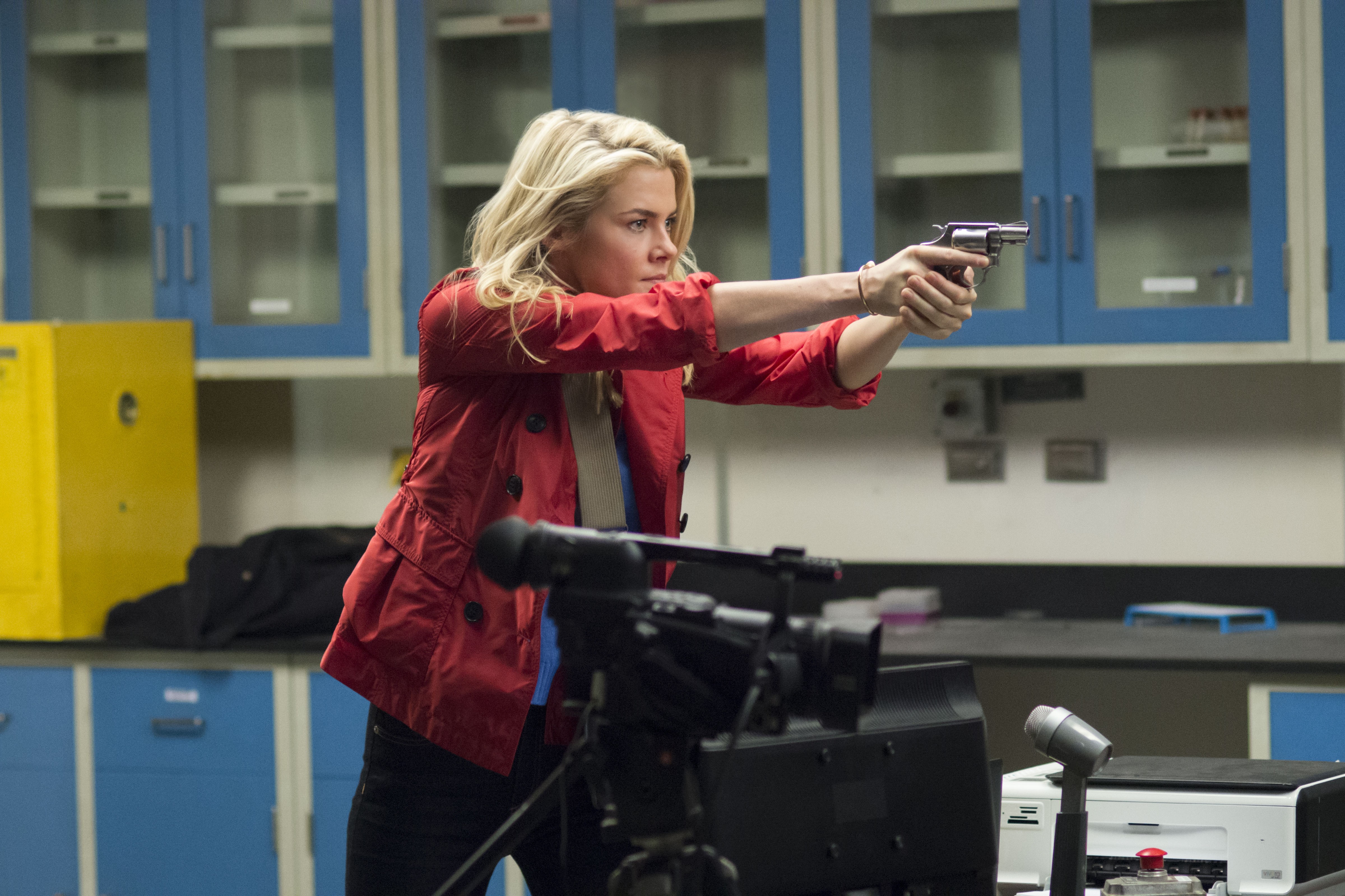 Rachael Taylor aiming a handgun in a lab HD Wallpaper